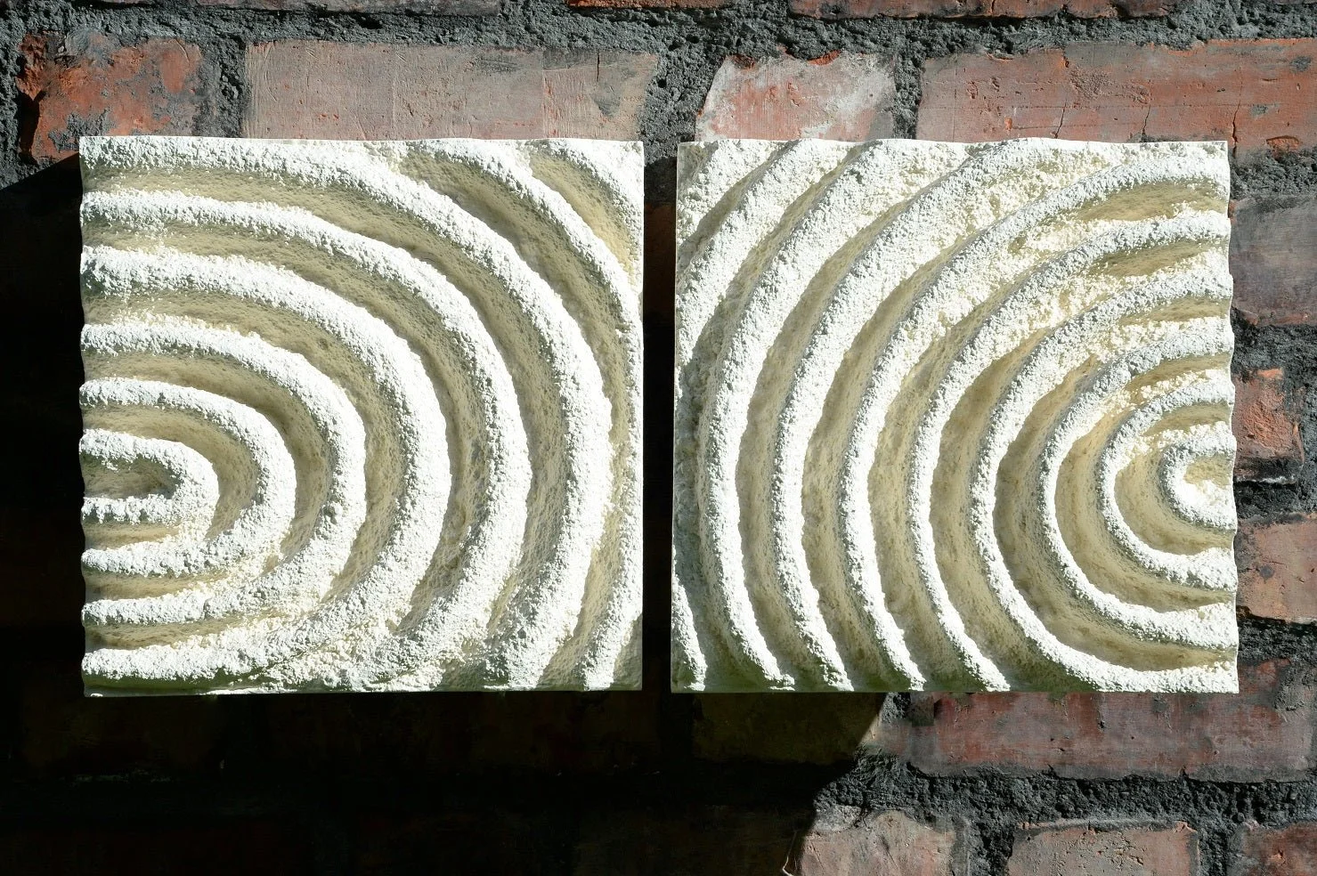 Close view of the Echo Sound wall sculpture showing the concentric carved ripples across both panels