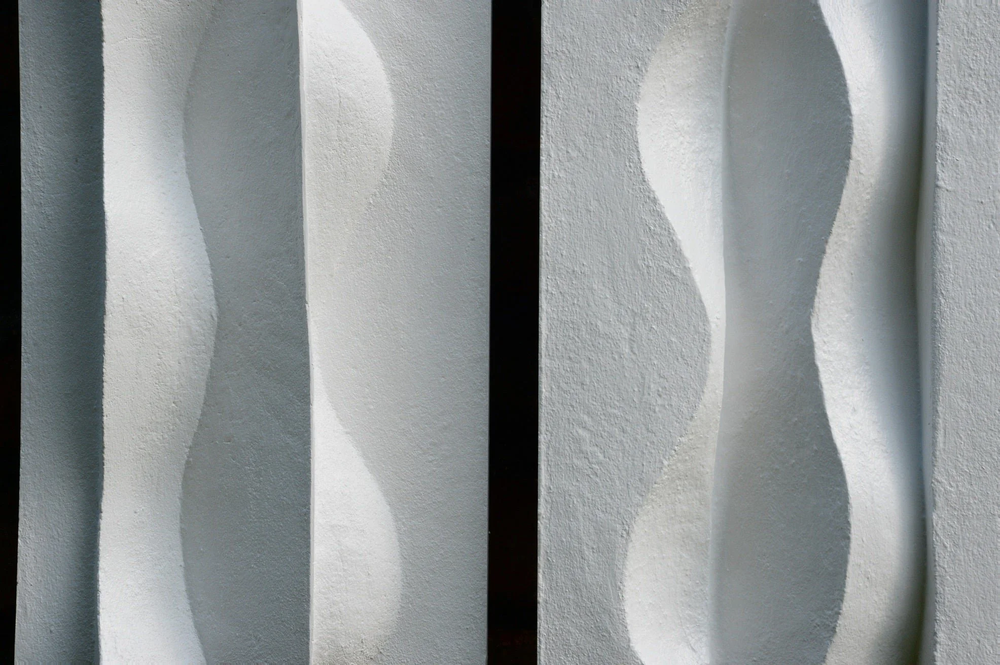 Close view of the Brancusi wall sculpture showing the soft vertical curves of the carved relief
