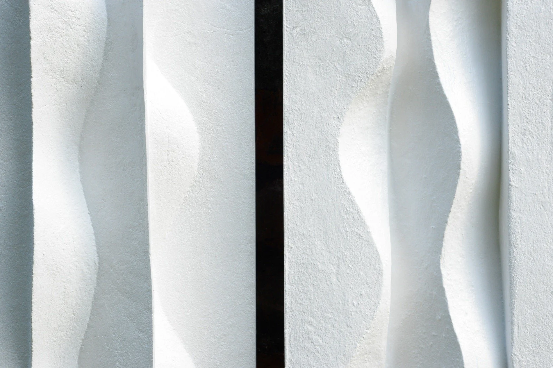 Close detail of the Brancusi wall sculpture, the carved waves catching light and shadow