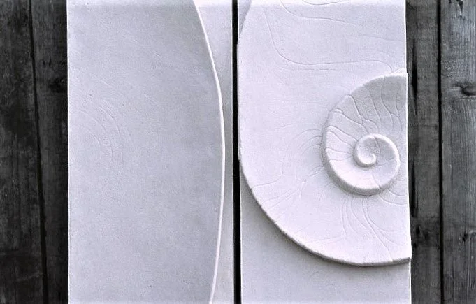 Close view of the Moon and Shellwave wall sculpture showing the carved spiral beside the crescent panel