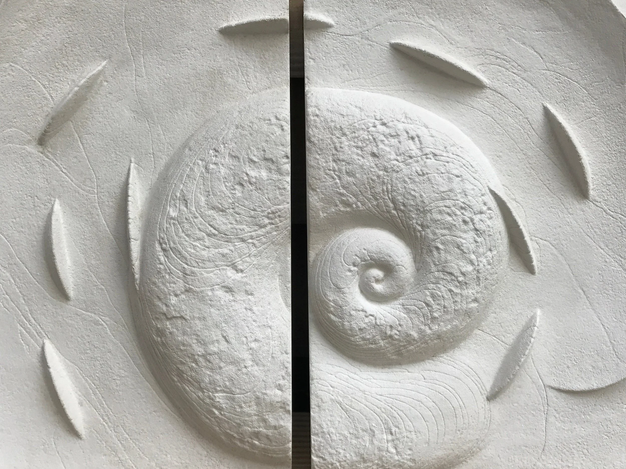 Spiralfish Wave and Tide wall sculpture in white, its carved spiral flanked by curved fin blades