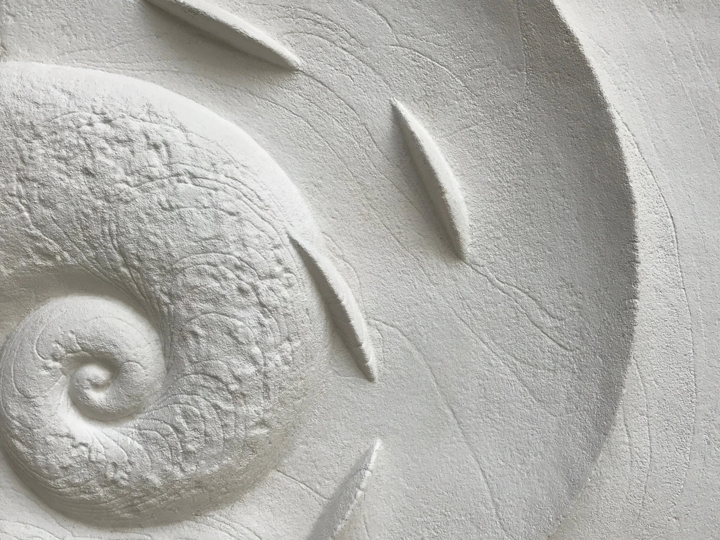 Close detail of the white Spiralfish Wave and Tide relief showing the spiral coil and textured surface