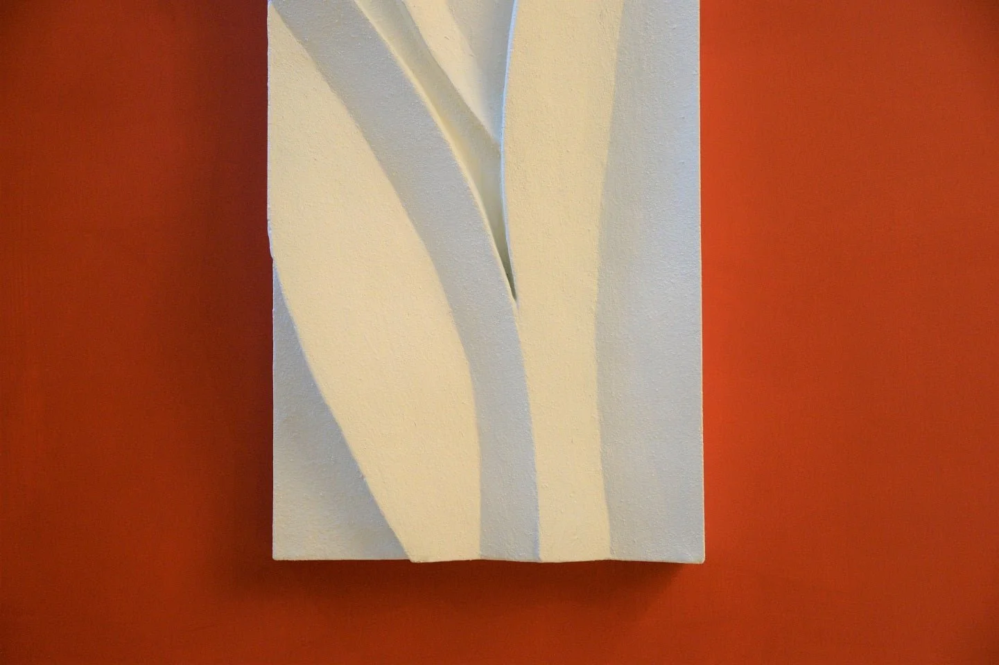 Magnolia Leaves wall sculpture seen closer, the carved leaf blades standing out against a terracotta wall