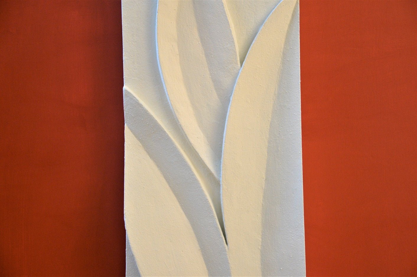 Detail of the Magnolia Leaves wall sculpture showing the long carved leaves rising up the panel