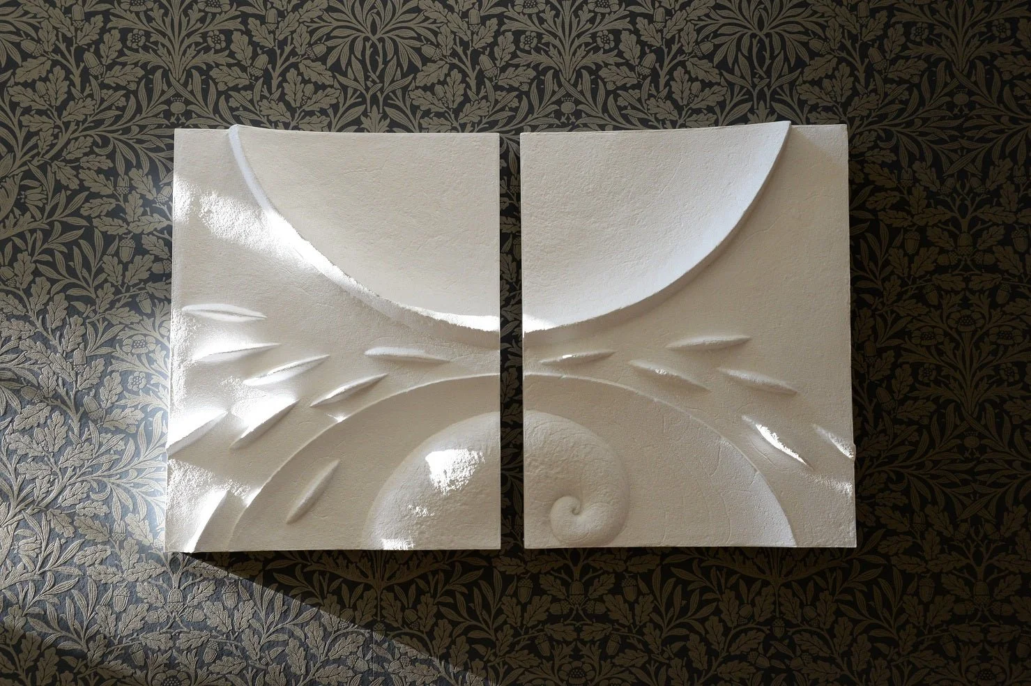 Moon Fishwave wall sculpture, two white stone-finish panels forming a curved fin and wave against a dark wall