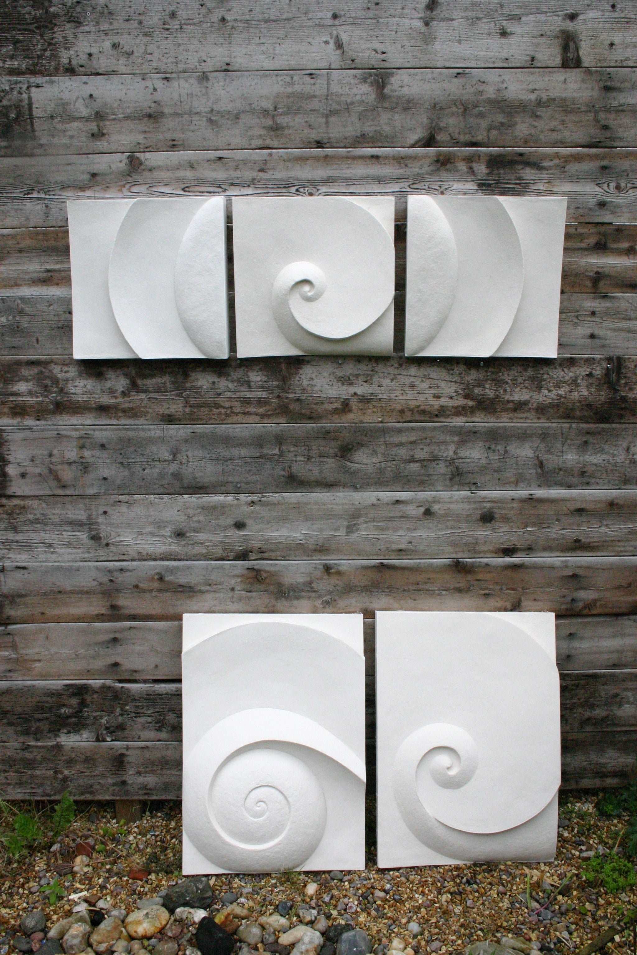 Wave Between Moonshadow wall sculpture arranged as four offset panels on a grey timber wall