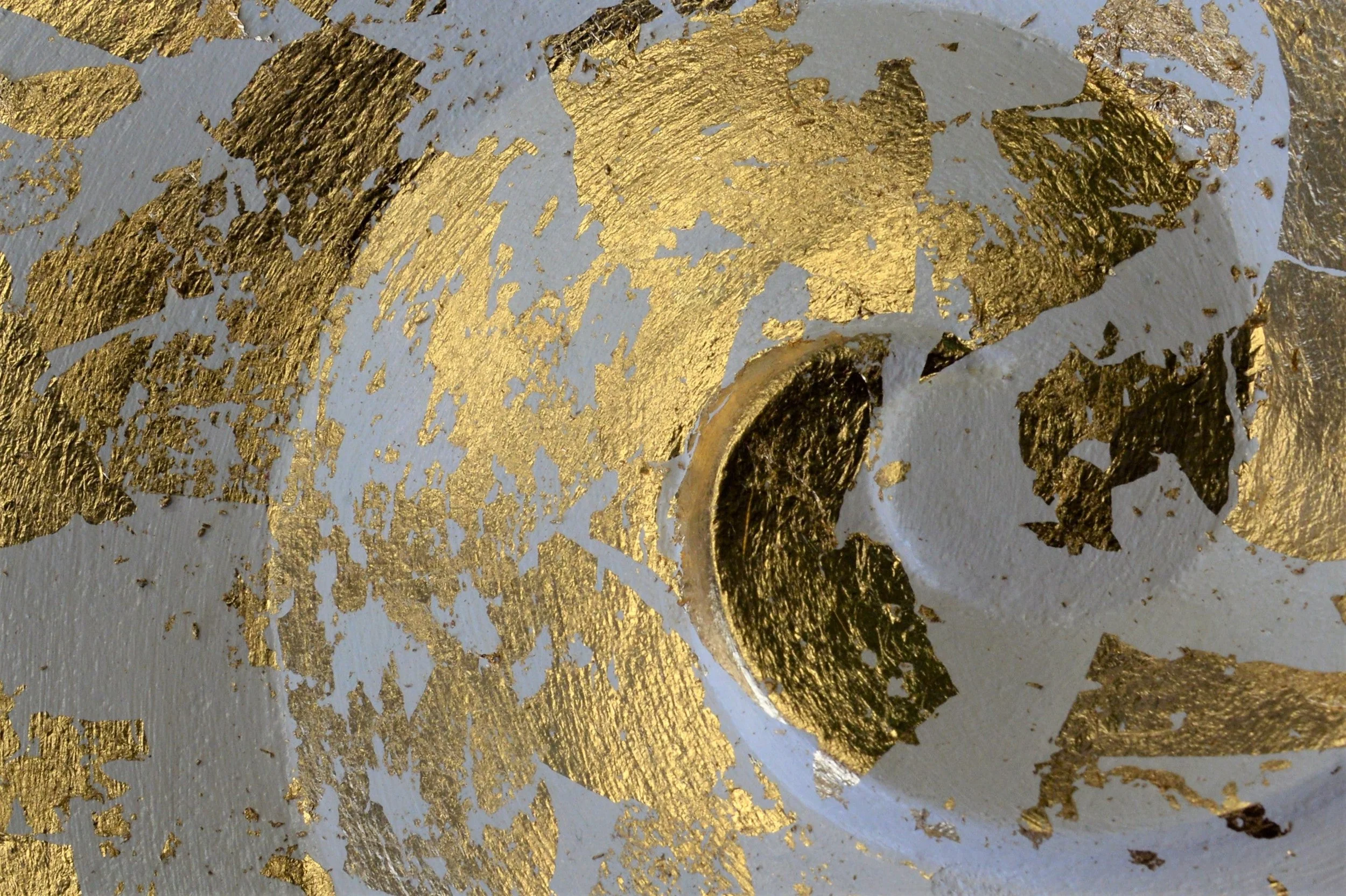 Close view of the Golden Spiral wall sculpture, showing gold leaf breaking over the carved spiral hollow
