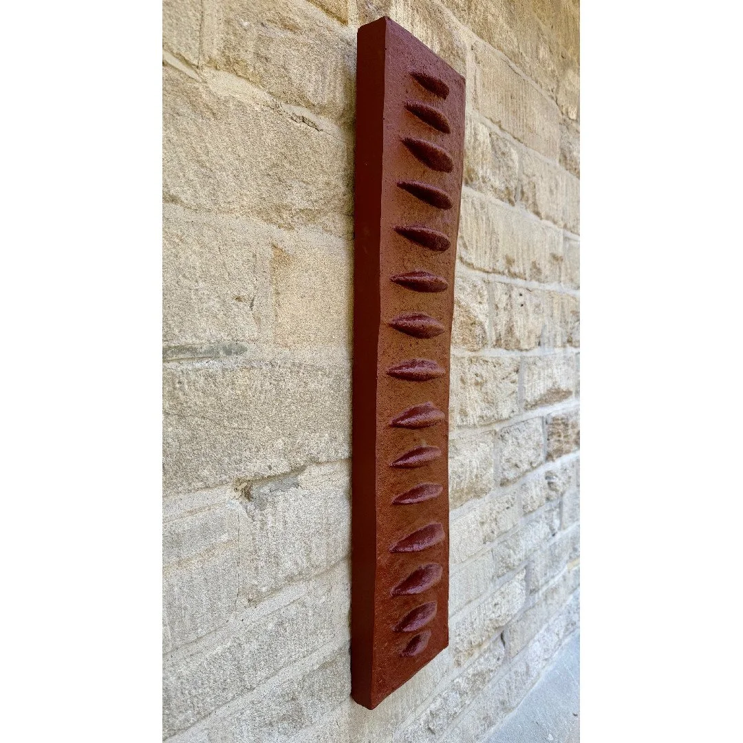 Frozen Fish wall sculpture viewed from the side, showing how the ribbed terracotta-effect panel stands off the wall