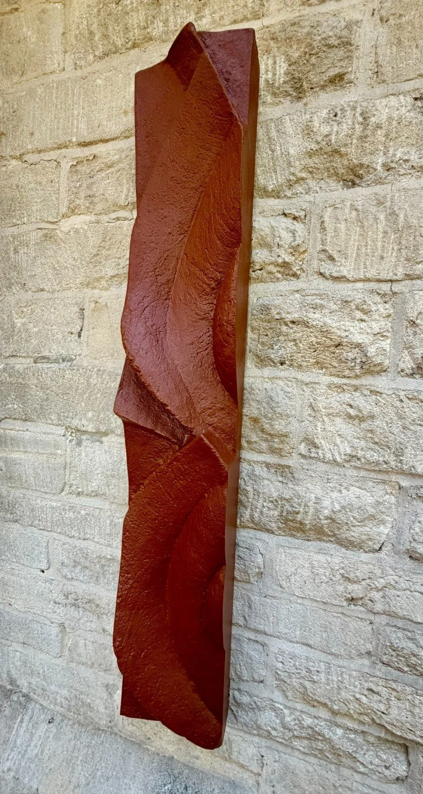 Frozen Deco wall sculpture seen from the side, showing how the terracotta-effect ribbon twists out from the wall