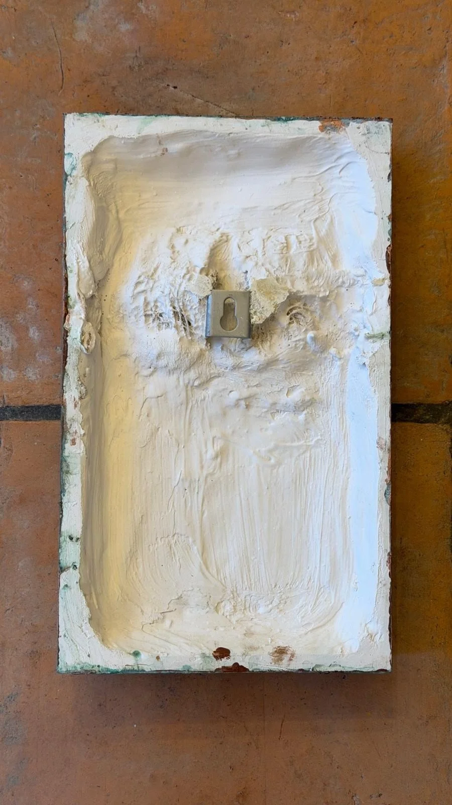 Reverse of the faux rust wave relief wall sculpture, showing the recessed white gypsum back and metal hanging fixing