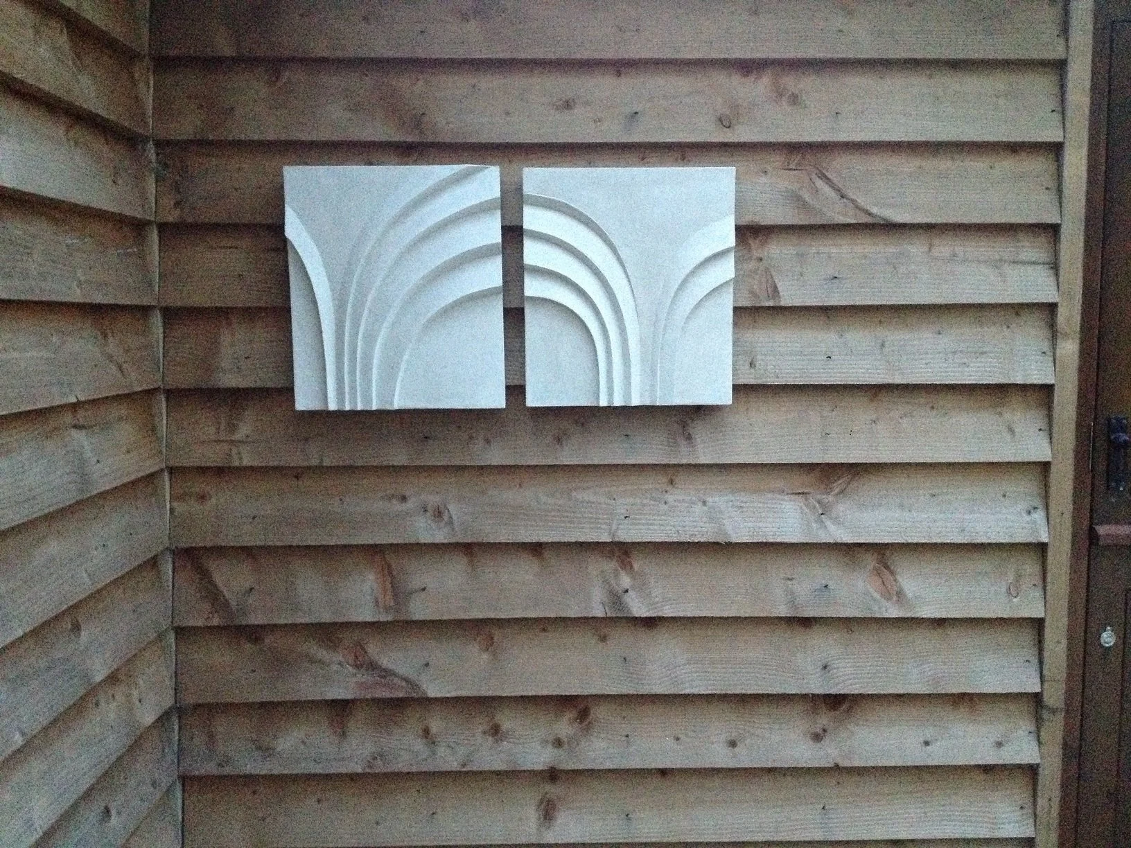 Detail of the Two Palm Forms with Spiral wall sculpture showing the carved palm frond ribs in raking light