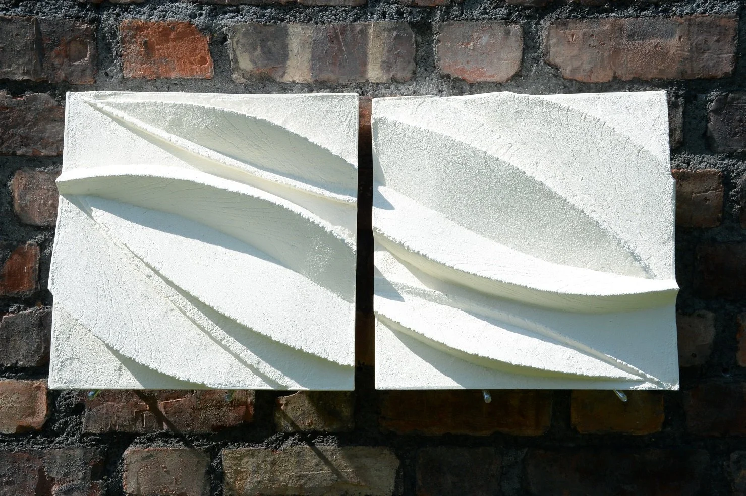 Detail of the Leaf Form wall sculpture showing the carved leaf relief and its cast shadows in raking light