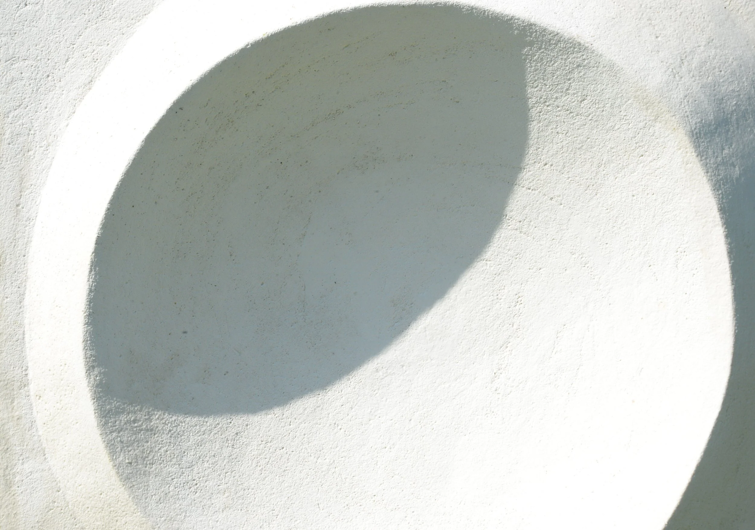 Close-up of the Moonwater Catcher concave bowl, its stone-finish surface curving from bright light into deep shadow