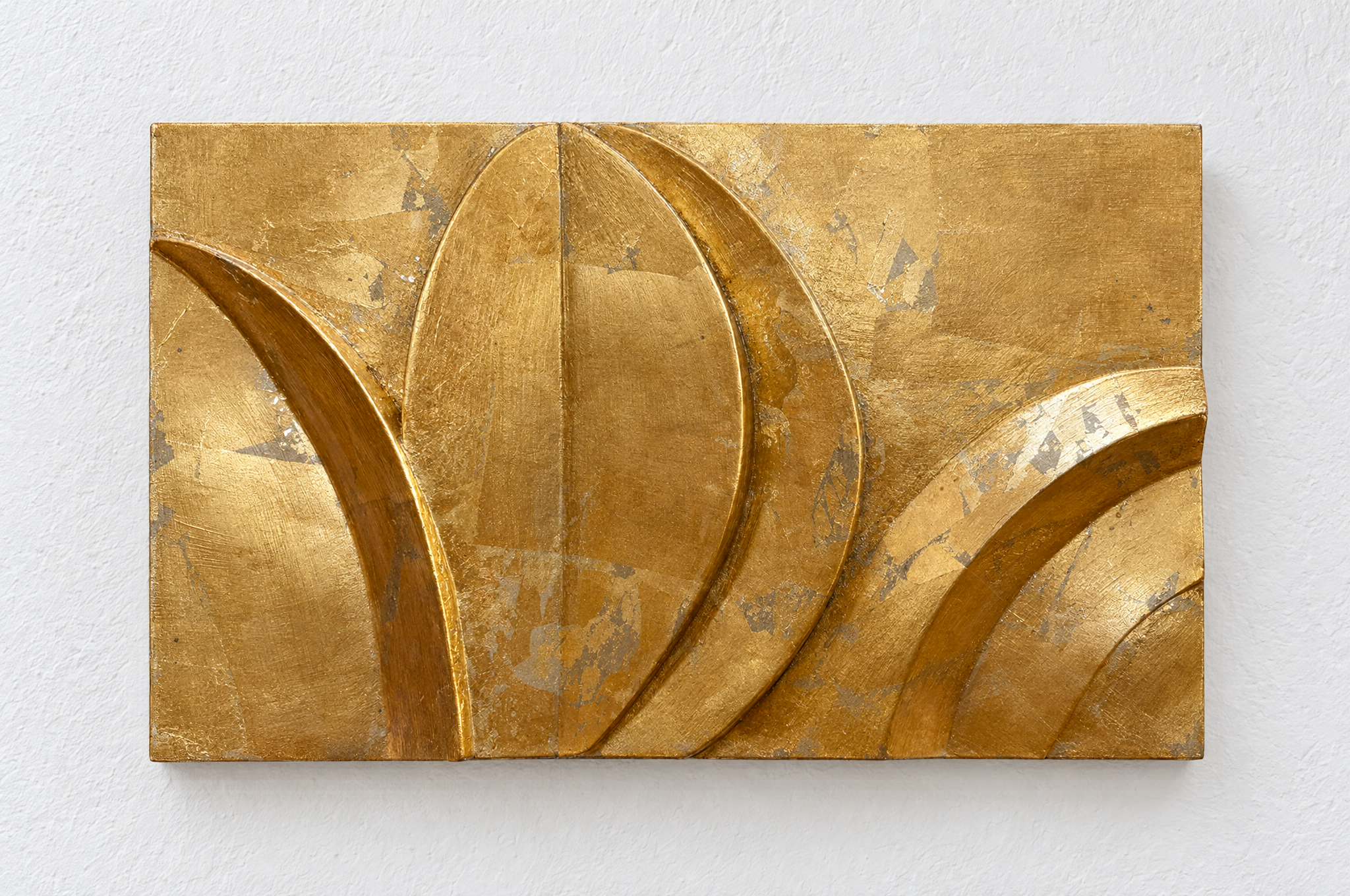 Gold-coloured Acanthus and Moon relief with a central leaf form against a white background.