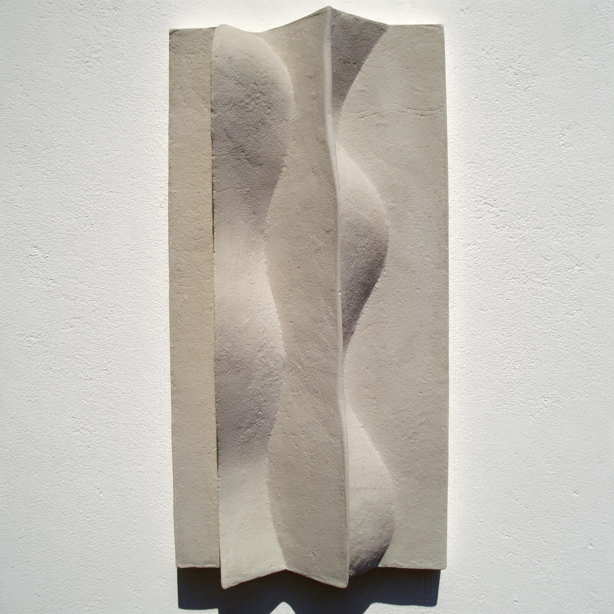 White Brancusi 2 relief with a flowing central ridge against a pale wall.