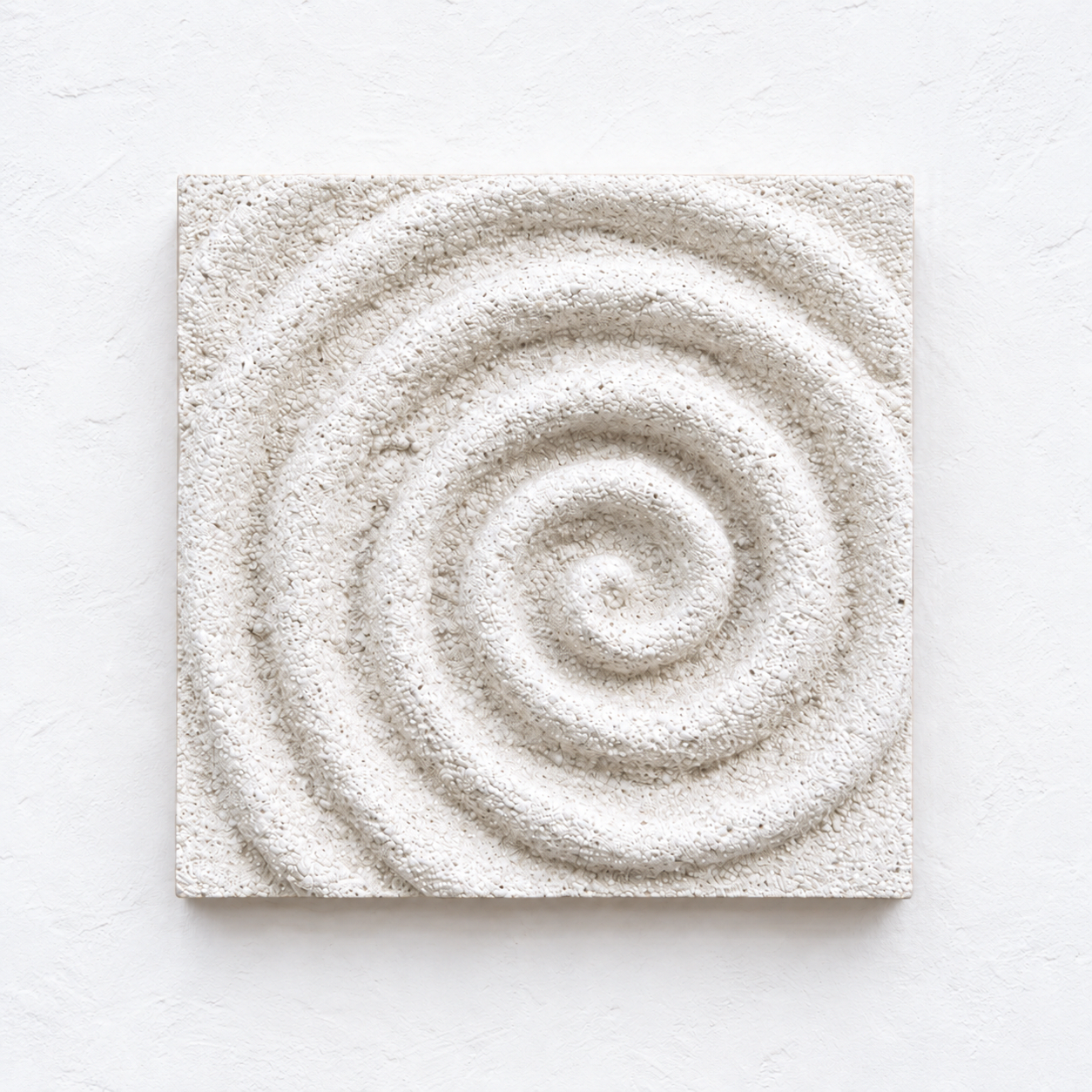 White square Spiral relief with a raised coiled ridge against a white background.