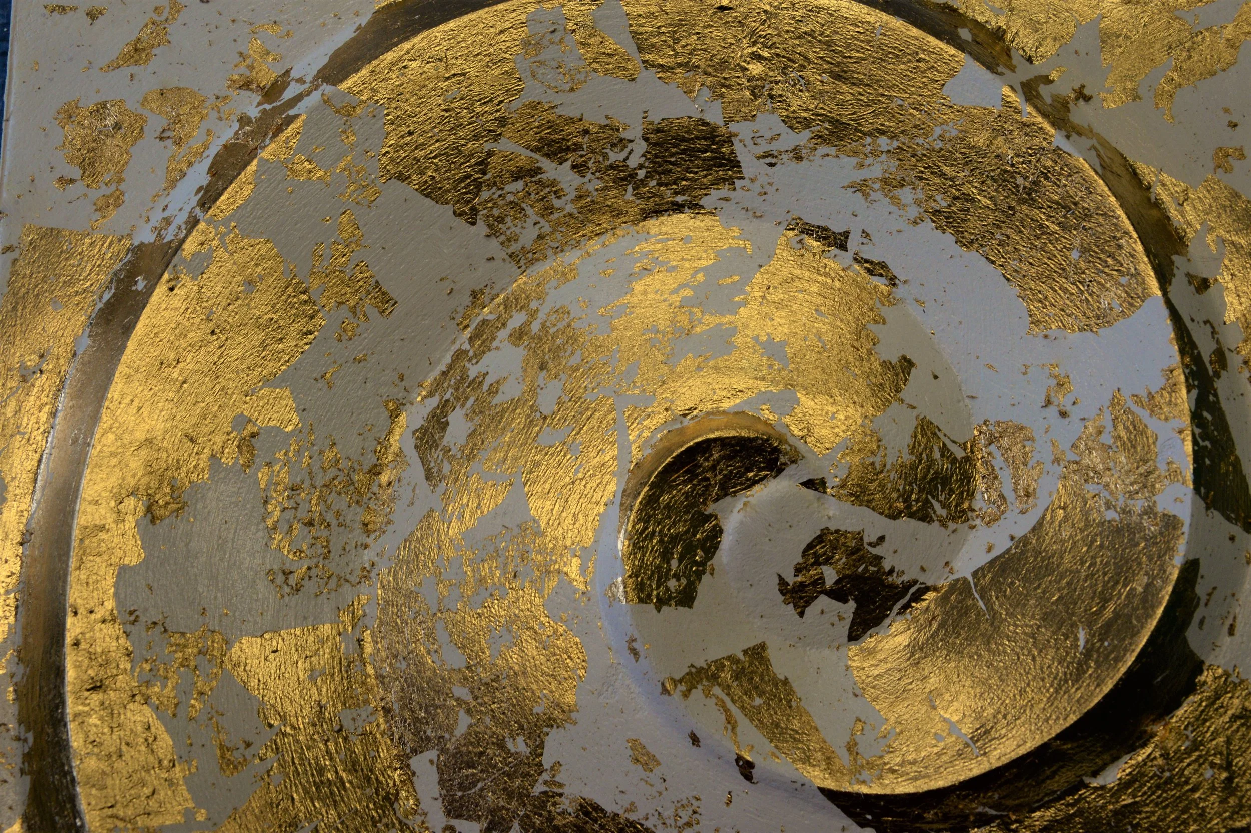 Close-up of the white and gold-coloured Deco Palm and Spiral relief, showing its coiled ridge.