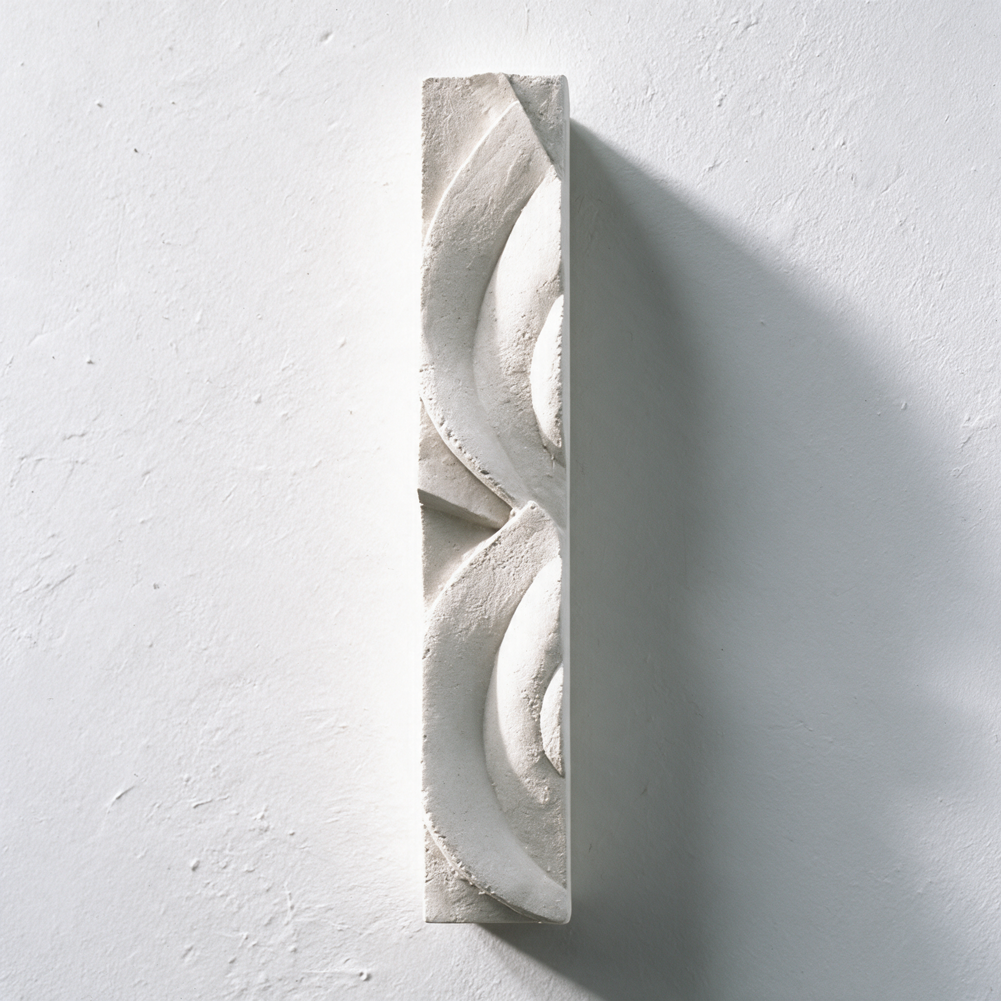 White Frozen Decowaves 1 relief shown vertically, with broad curves casting shadows on the wall.
