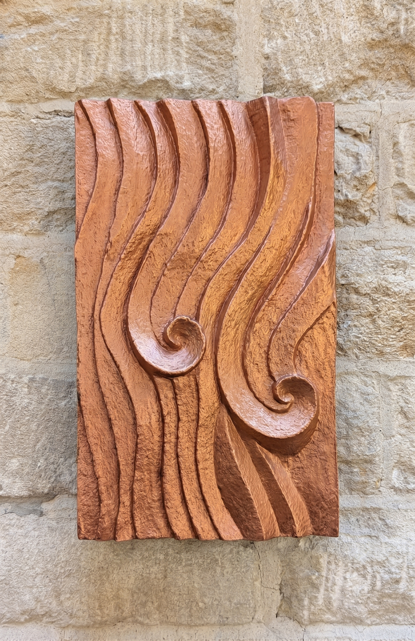 Copper-coloured Dune Ripple 2 relief with two spirals and flowing ridges on stone.