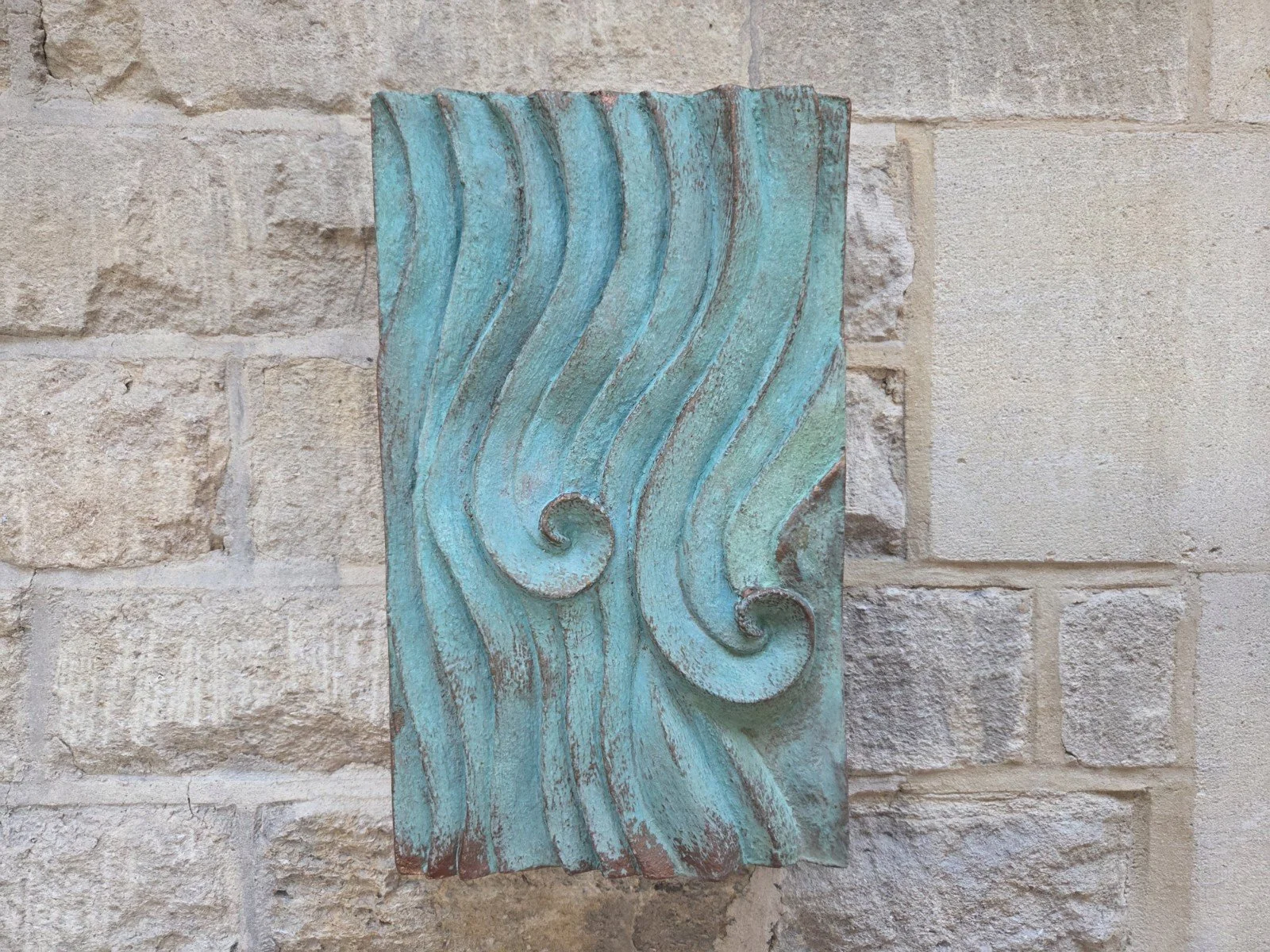 Verdigris Dune Ripple 2 with two spirals and flowing ridges on a stone wall.