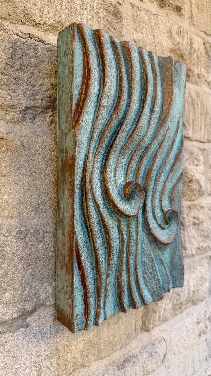 Angled view of Dune Ripple 2 with verdigris ridges and copper-brown edges on stone.