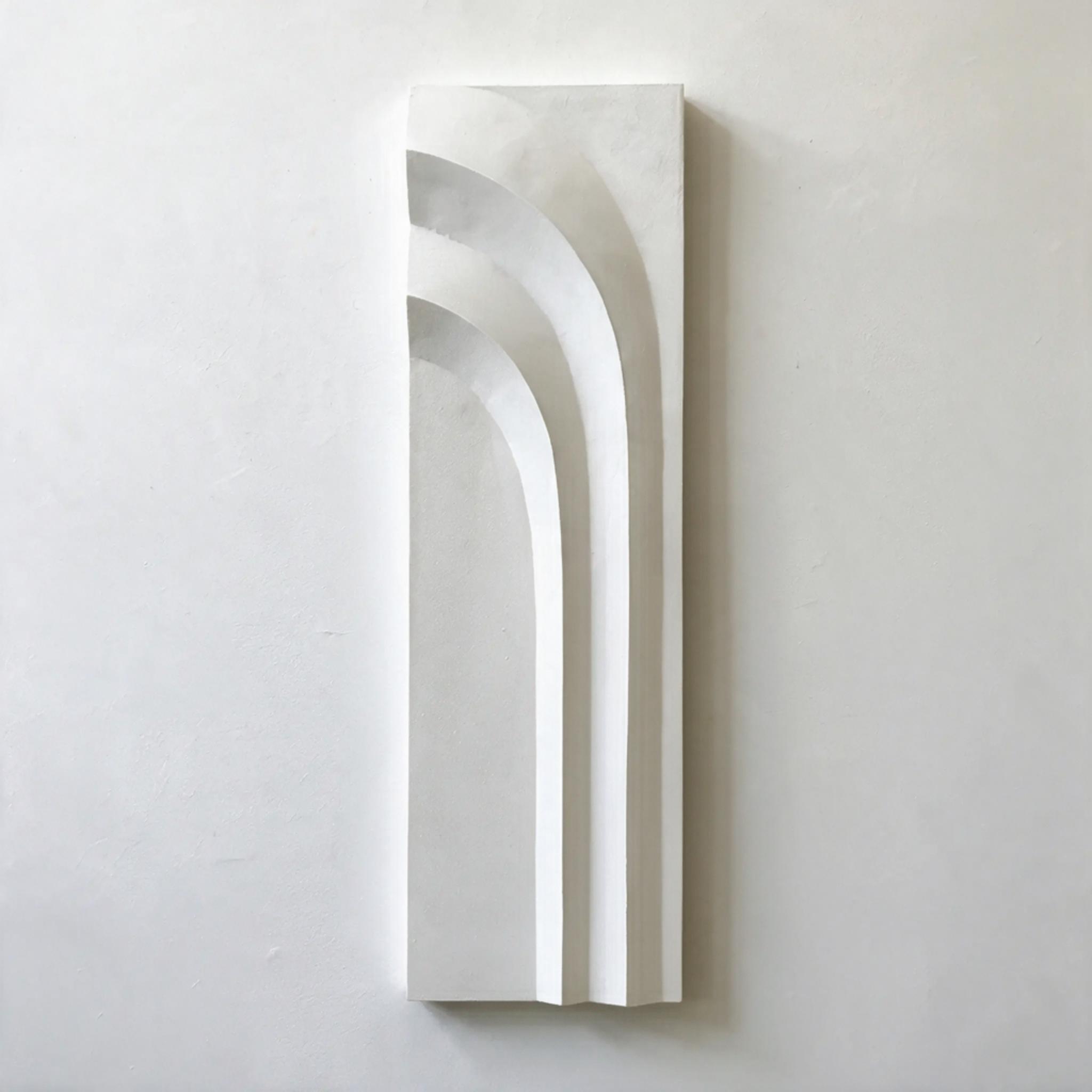 Tall white Egyptian Palm 4 Extended with three long curved bands against a pale wall.