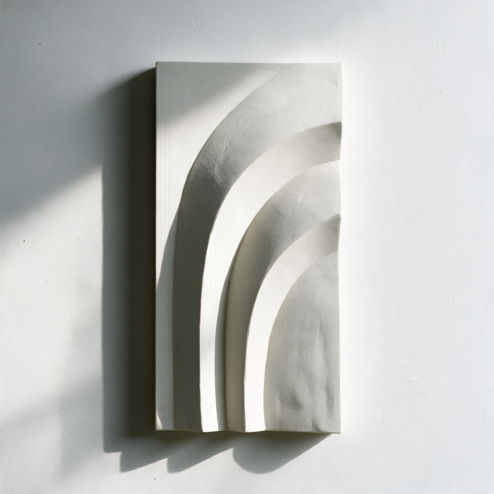 White Egyptian Palm 2 with curved bands and strong shadows against a pale wall.