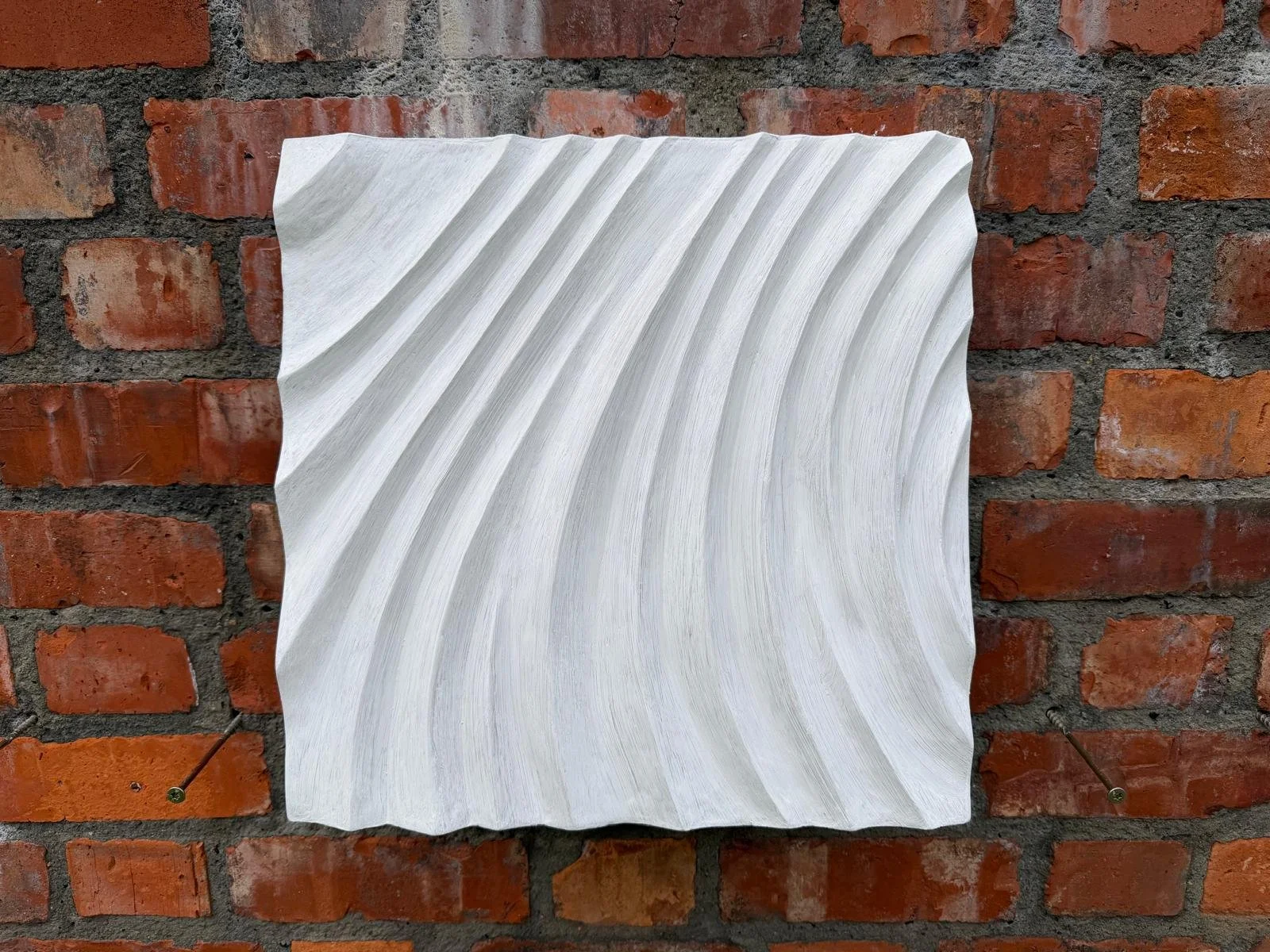 White Fingerprint Concentric 1 with parallel curved ridges mounted on brick.