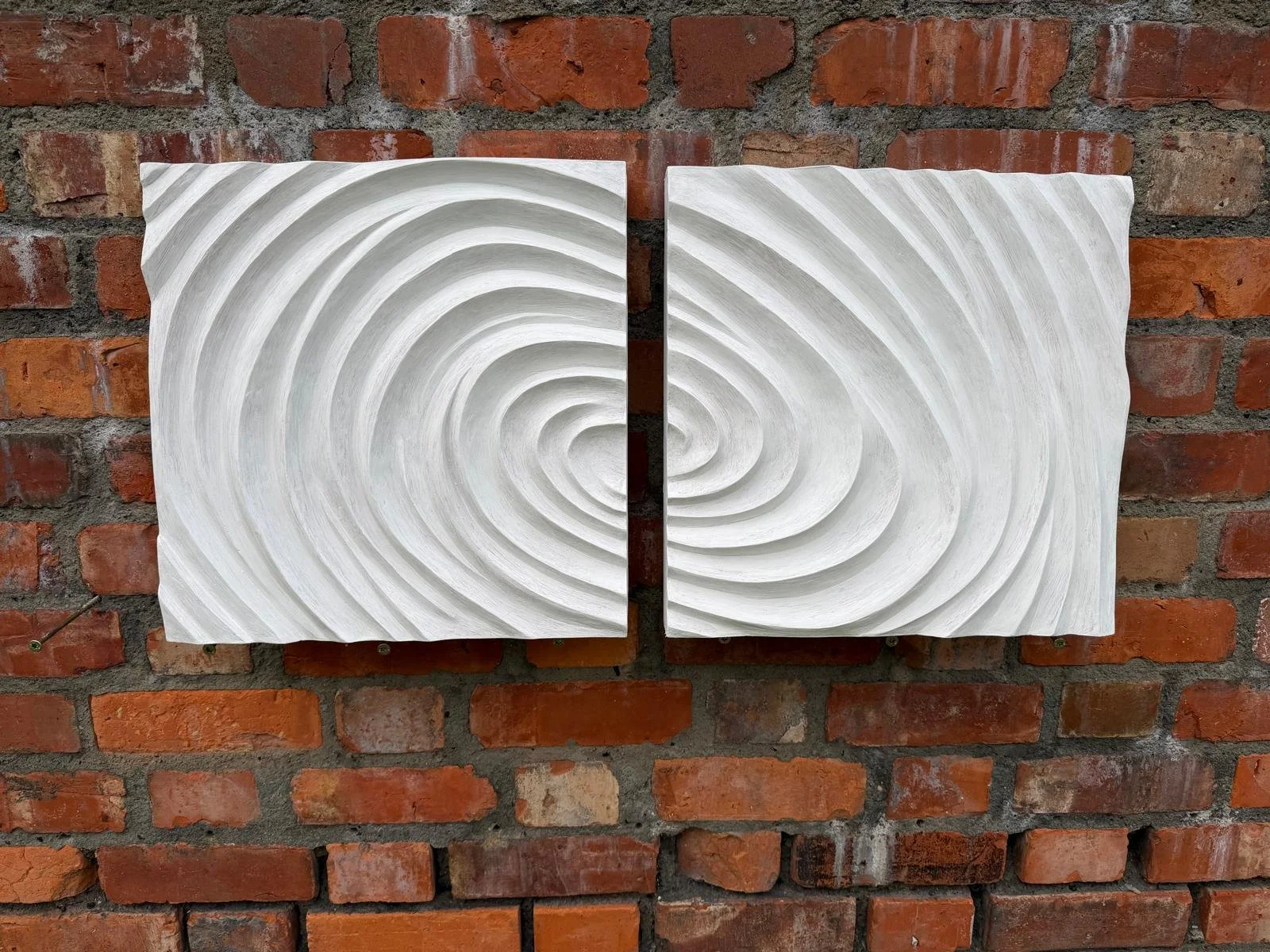 White Fingerprint Concentric 2 and 3 together on brick, forming a continuous oval ripple pattern.