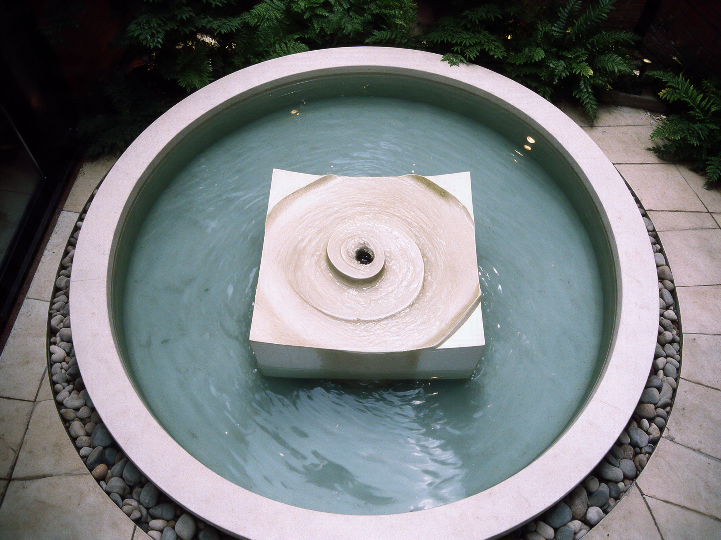 Knightsbridge Fountain viewed from above, with a spiral relief in the centre of a round water basin.