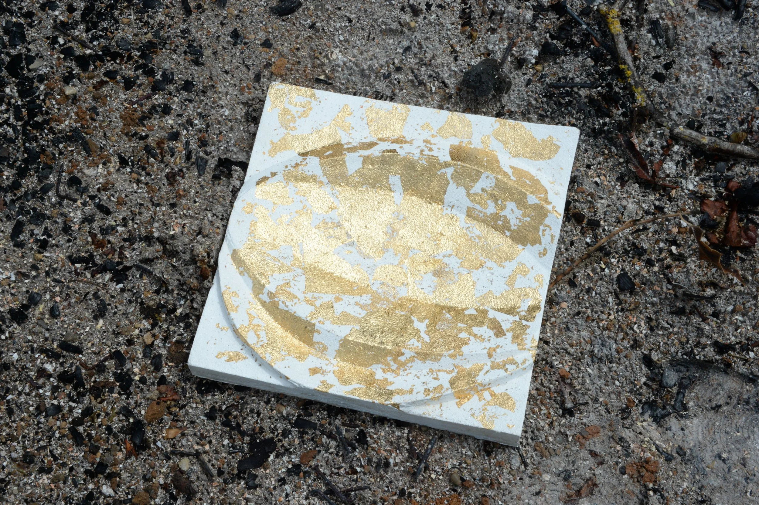 White and gold-coloured Leaf Curve relief resting on stone, with an oval curved recess.