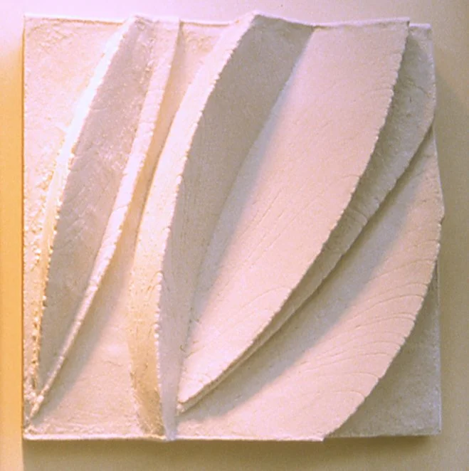 Close-up of white Leaf Form 1 in warm light, showing textured tapered leaves.