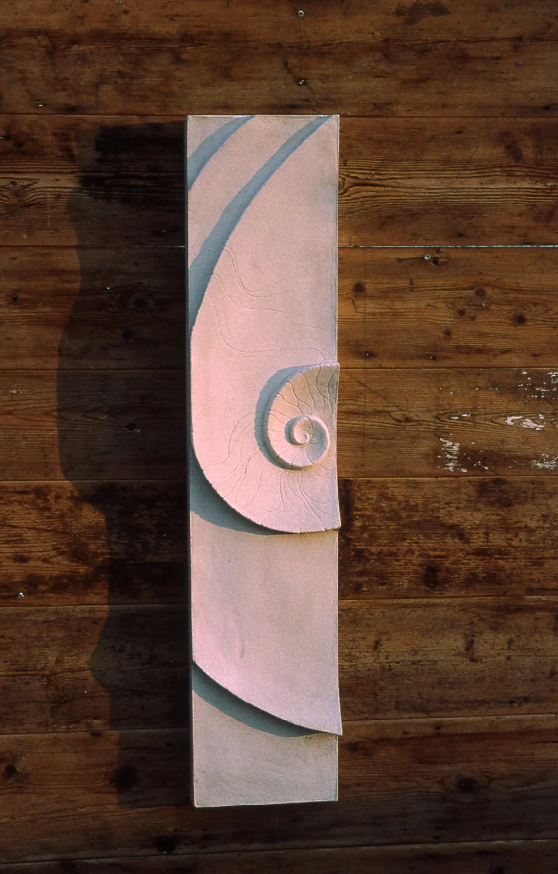 Front view of white Moon and Shellwave 1 displayed vertically on timber.