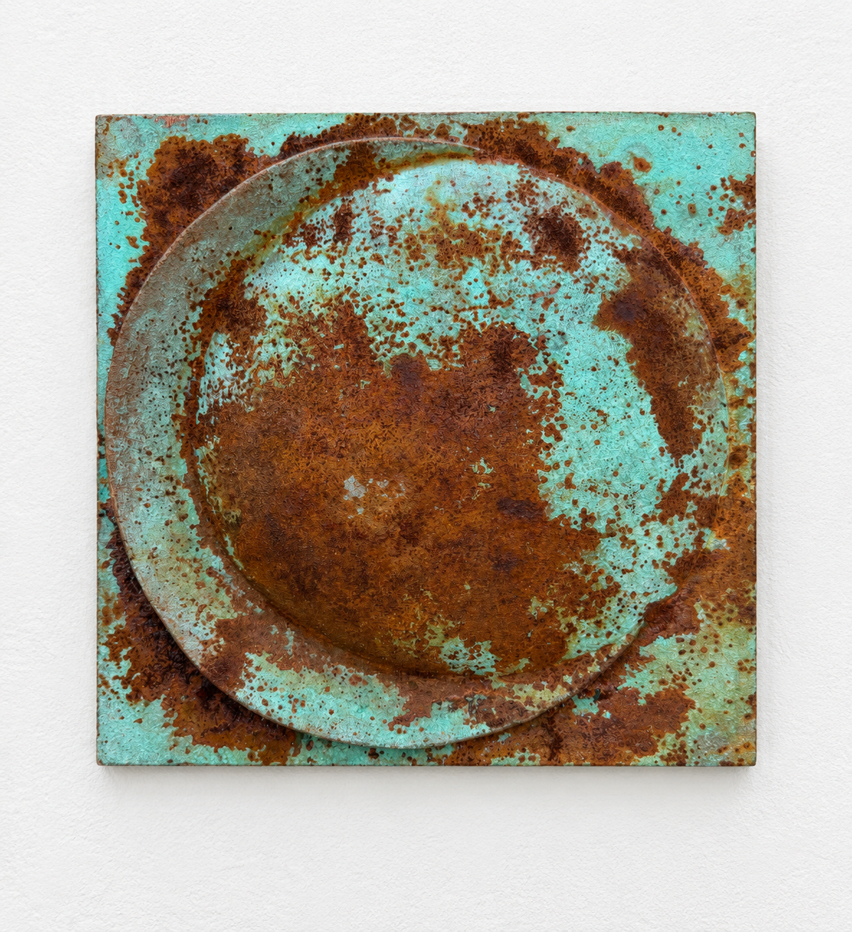 Verdigris and rust Moon Crater Phase 1 relief against white, showing a raised disc and circular band.