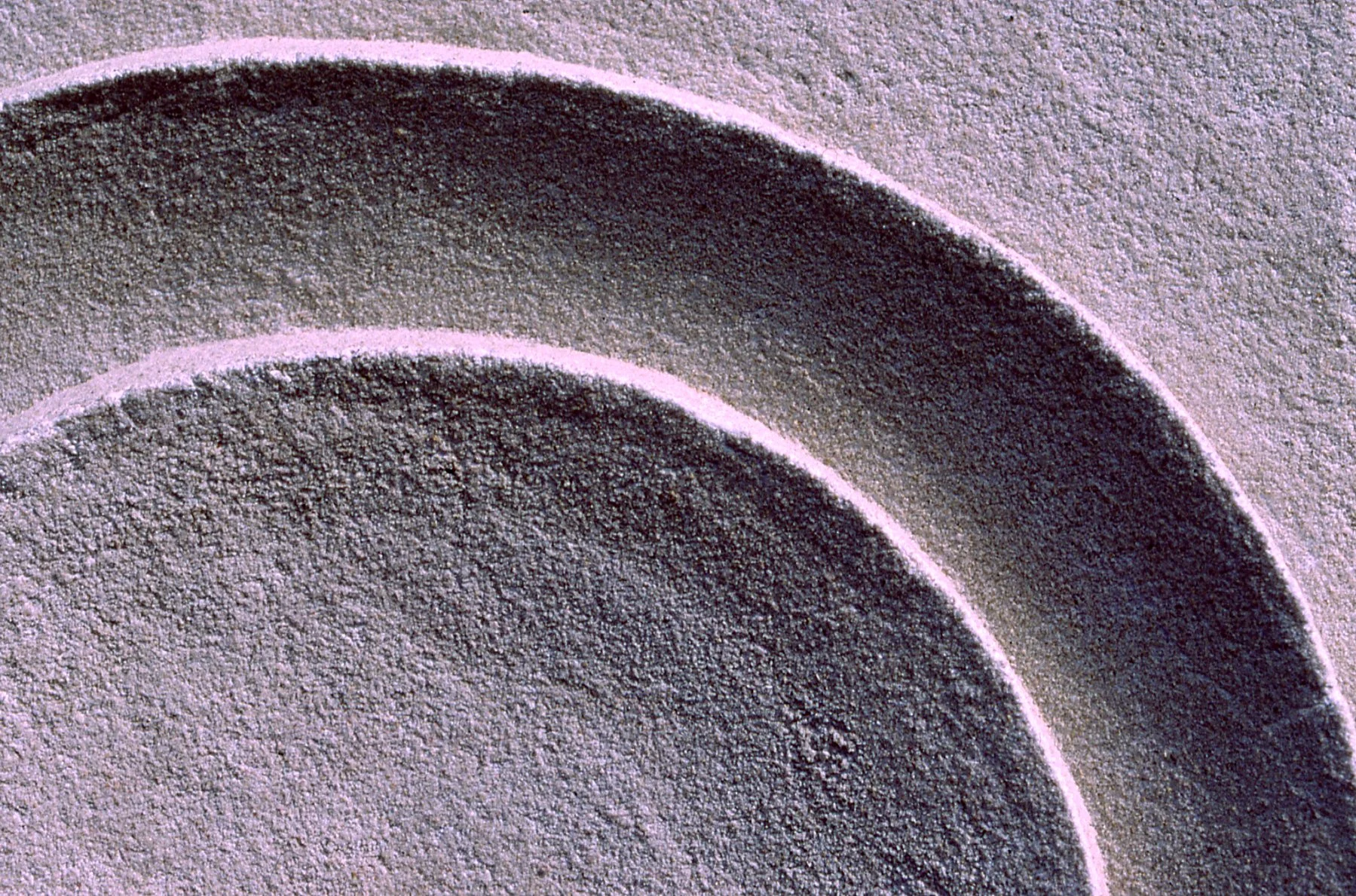 Close-up of the white Moon Ring relief, showing the texture and edges of its curved bands.