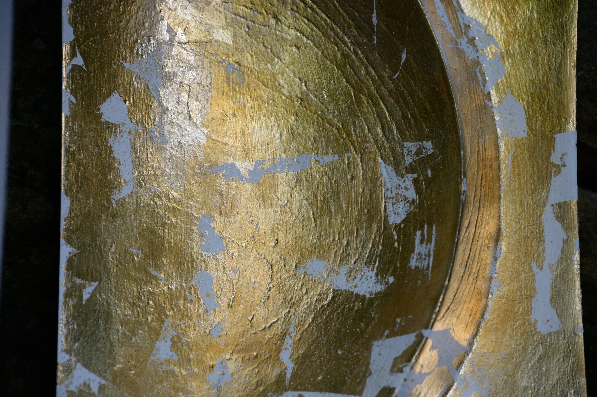 Angled detail of the gold-coloured curved bowl and textured white surface of a Moonphase relief.