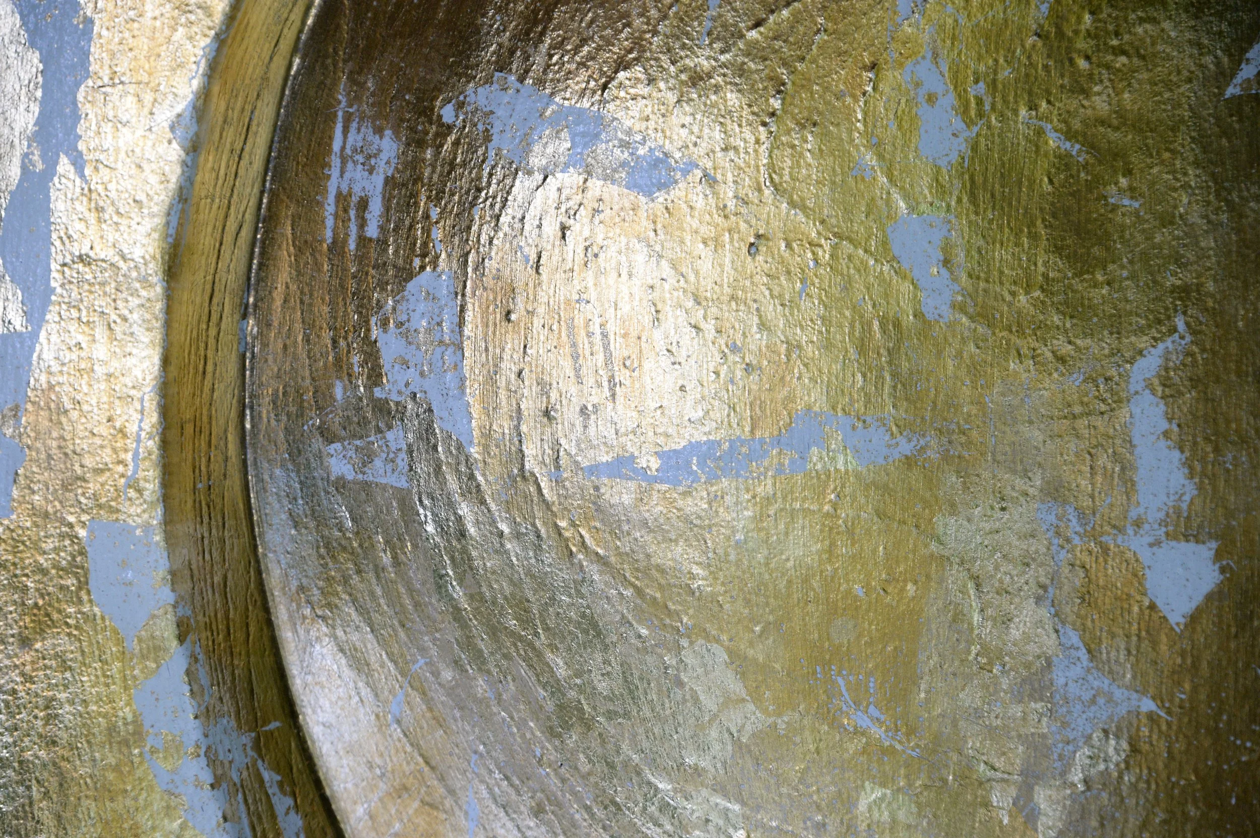 Close-up of a curved Moonphase relief with a mottled gold-coloured surface and white areas.
