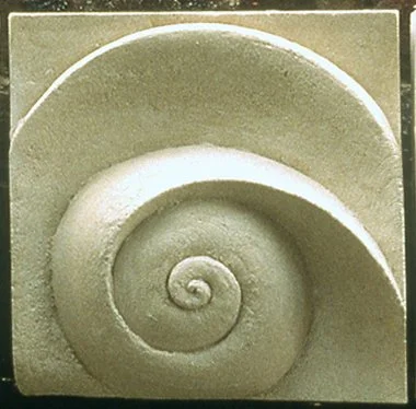White Moonphase 2 spiral relief photographed outdoors against a dark background.