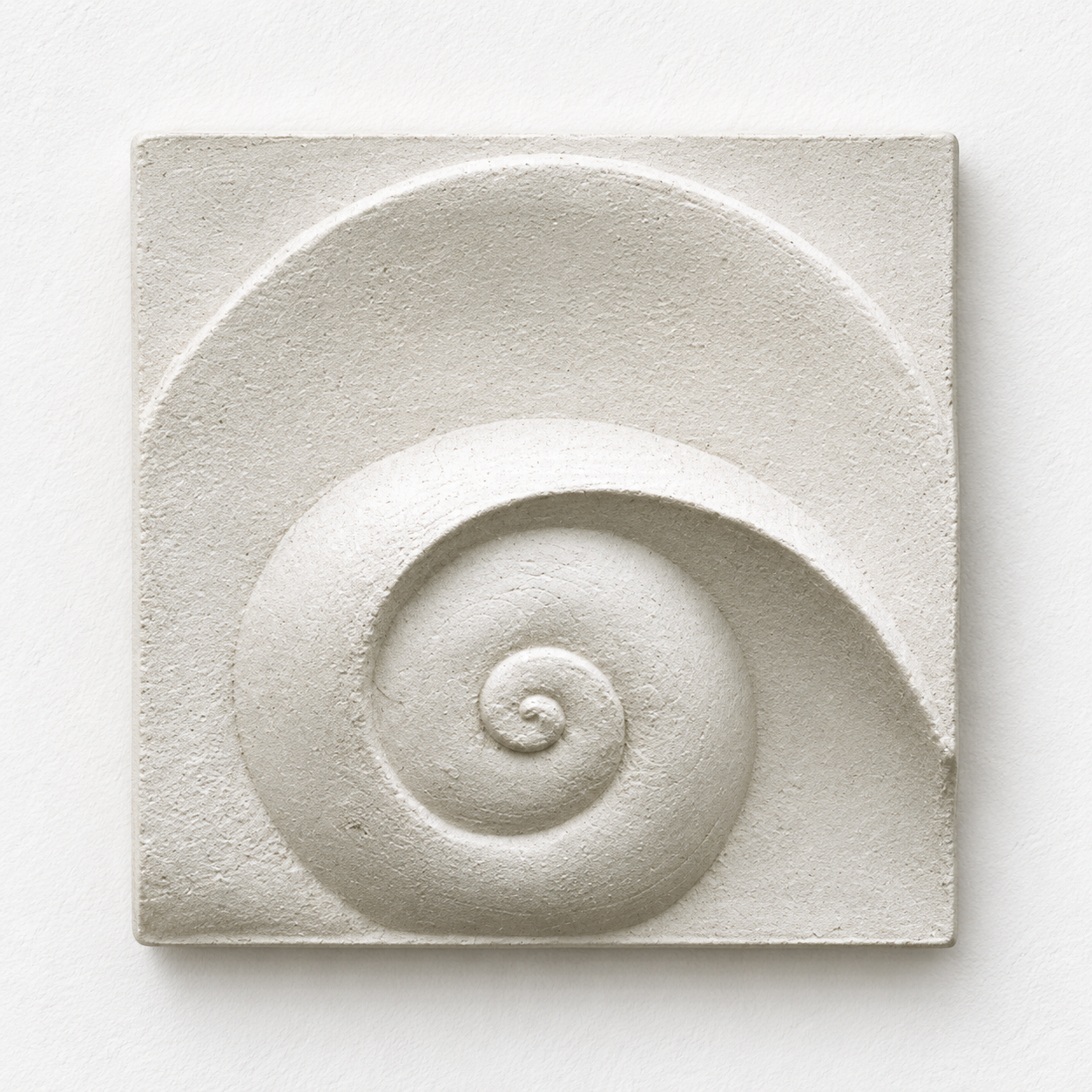 Front view of the white Moonphase 2 spiral and crescent relief against a pale background.