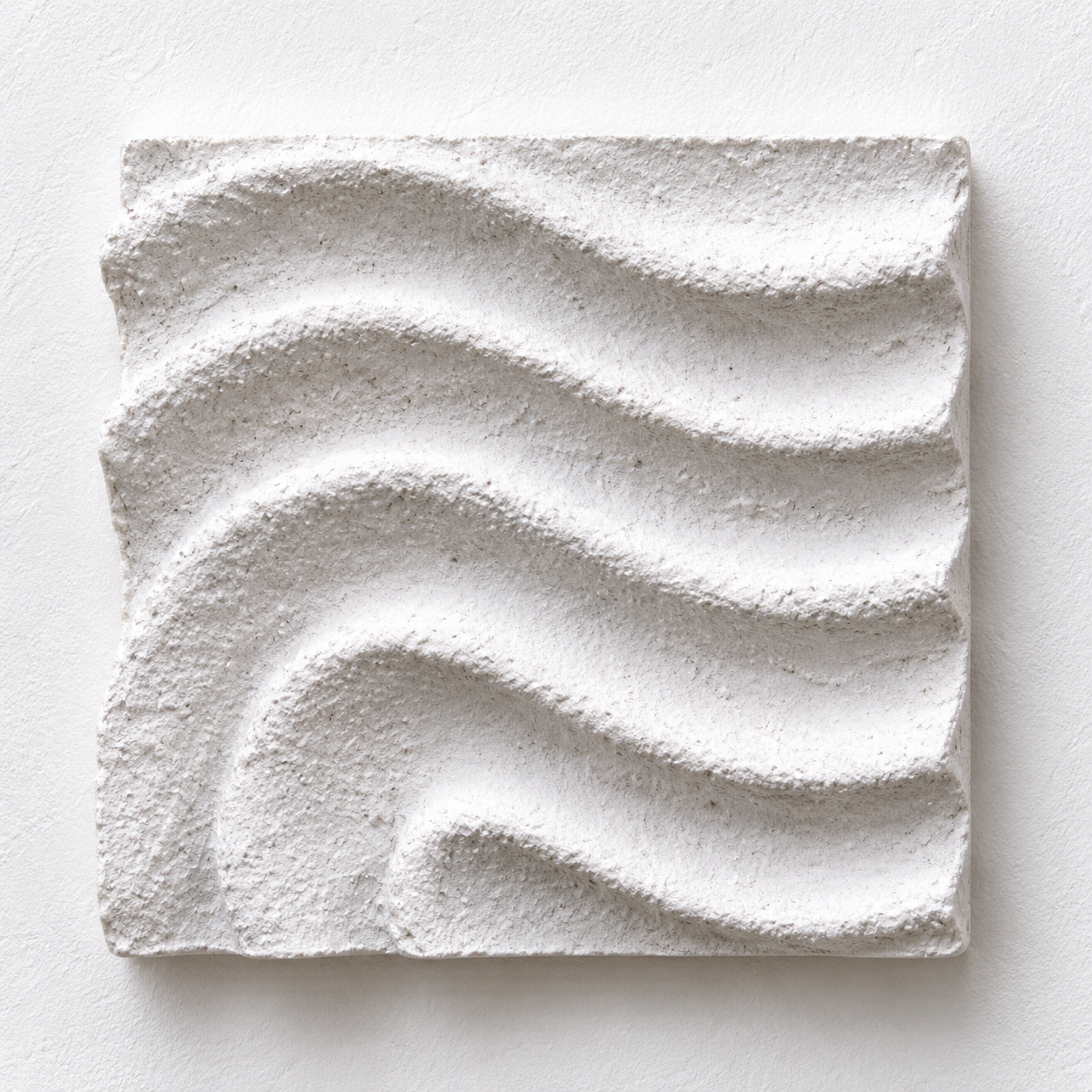 White Raked Spiral 2 relief arranged horizontally against a pale background.