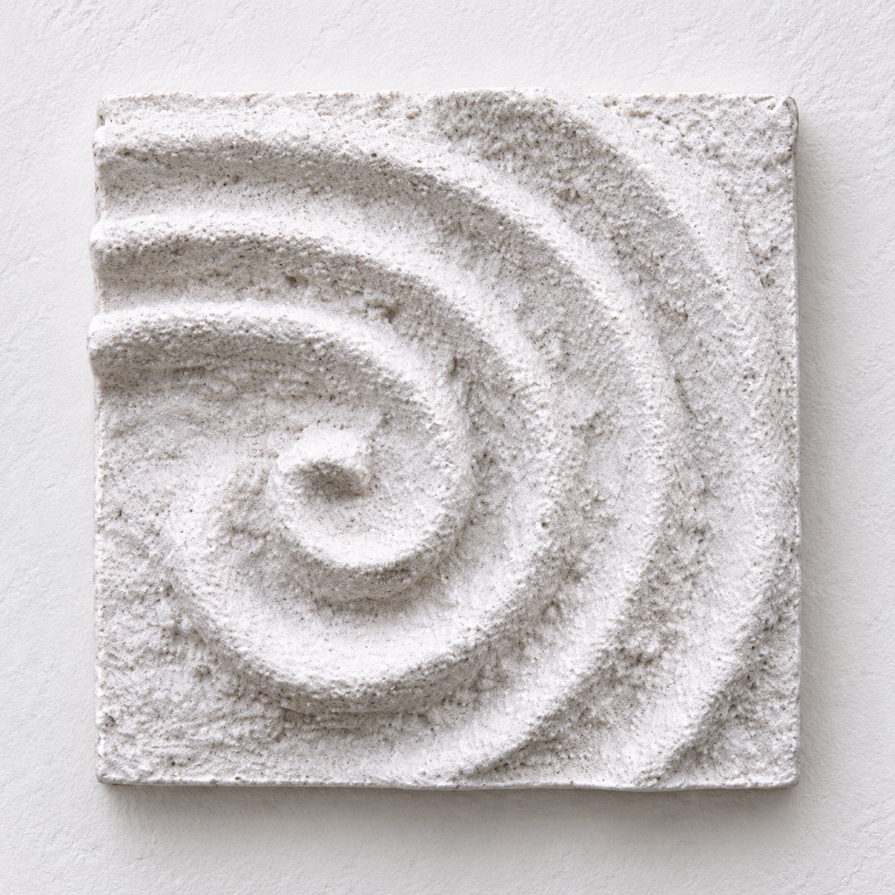 White Raked Spiral 3 textured spiral relief against a pale background.