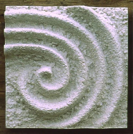 White Raked Spiral 3 relief with a rough spiral at the left, photographed in outdoor light.