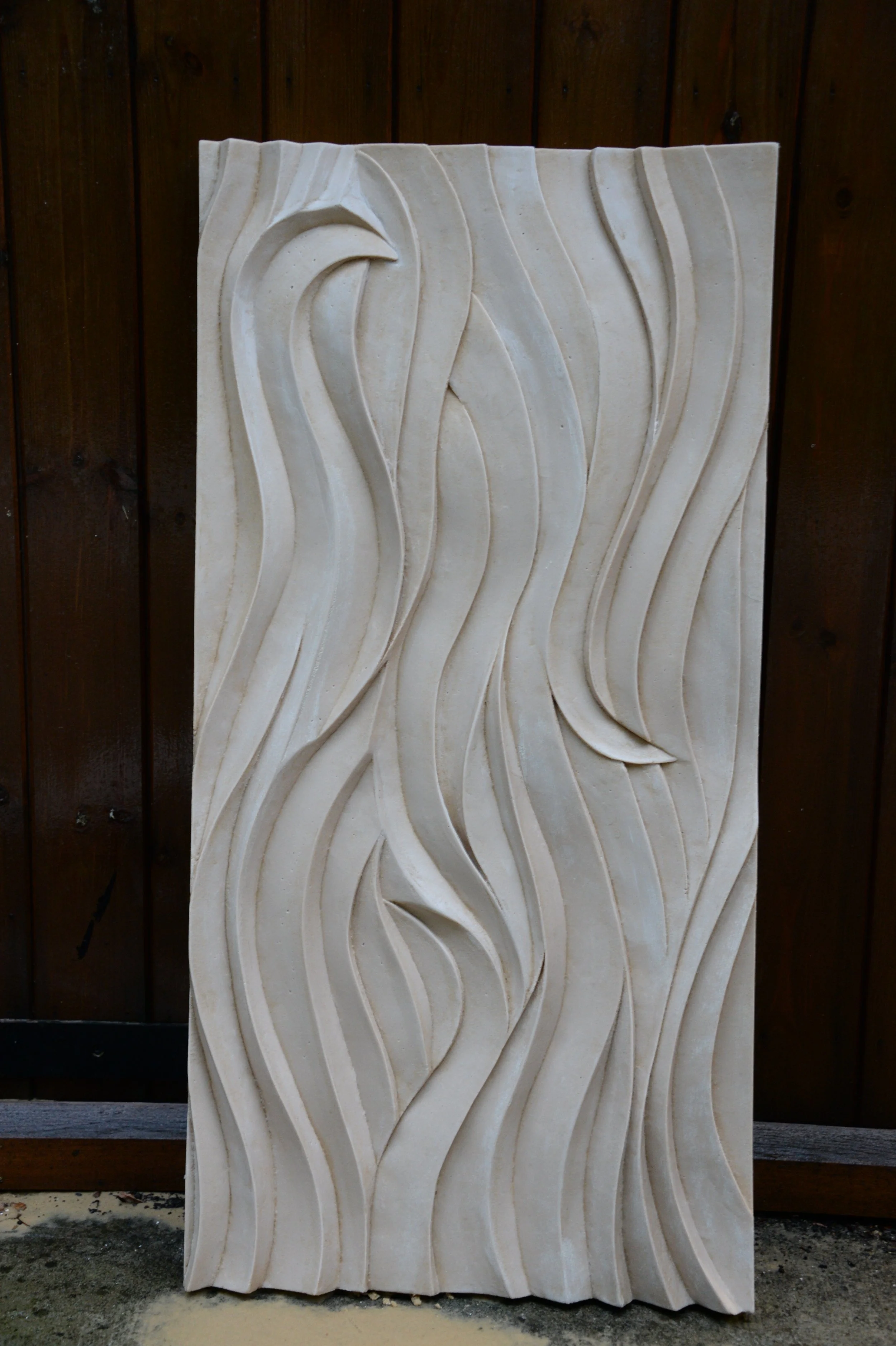 Tall white Seaweed Ripple Smooth wave panel photographed outdoors against dark timber.