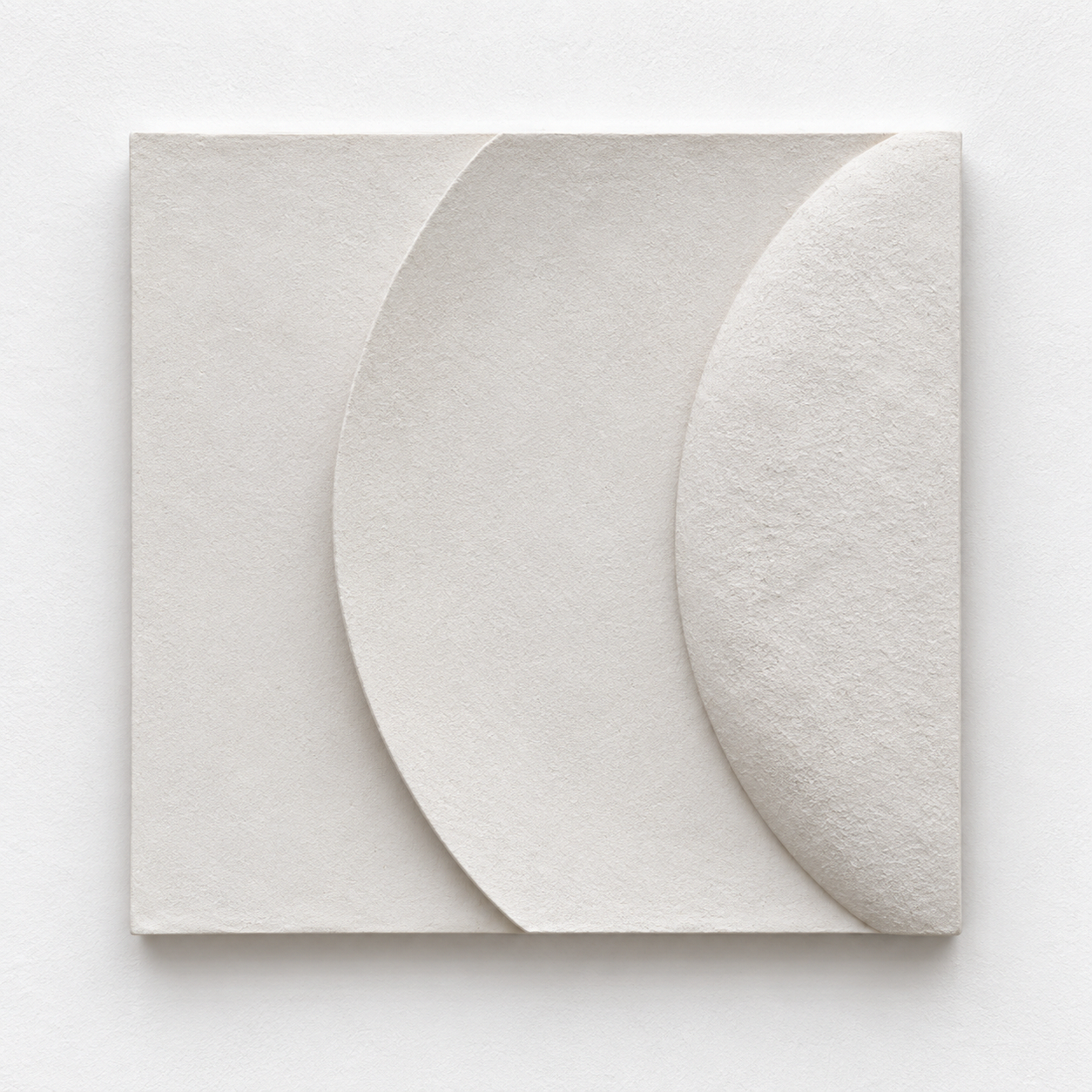 Angled view of the white Wave and Moonshadow 2 crescent relief against a pale background.