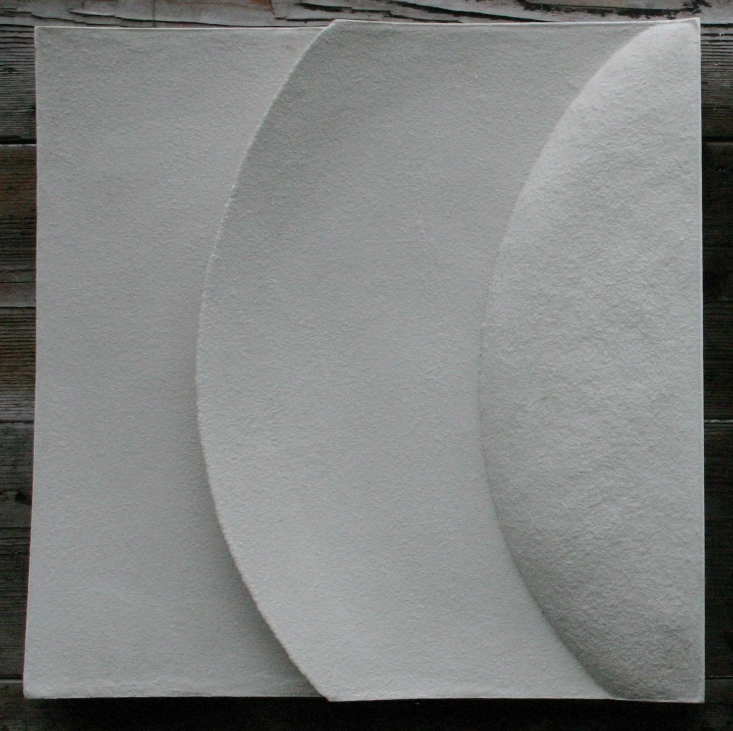 White Wave and Moonshadow 2 curved band relief photographed against a dark wall.