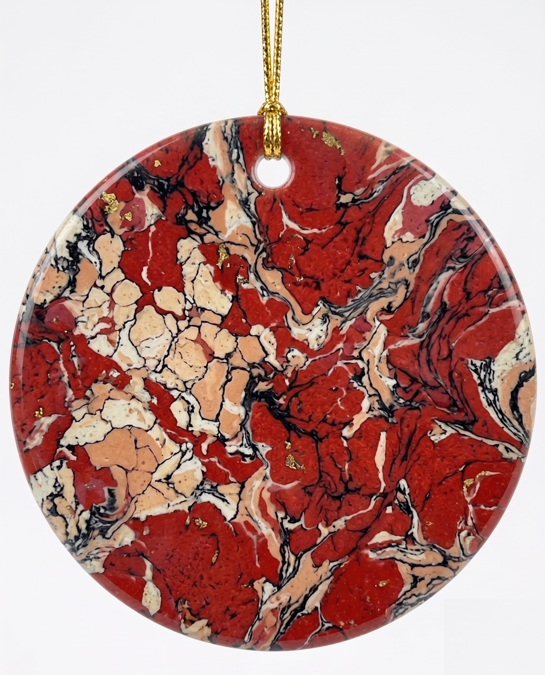Red Crystal Christmas ornament, a round marbled disc in red, cream and black on a gold hanging cord