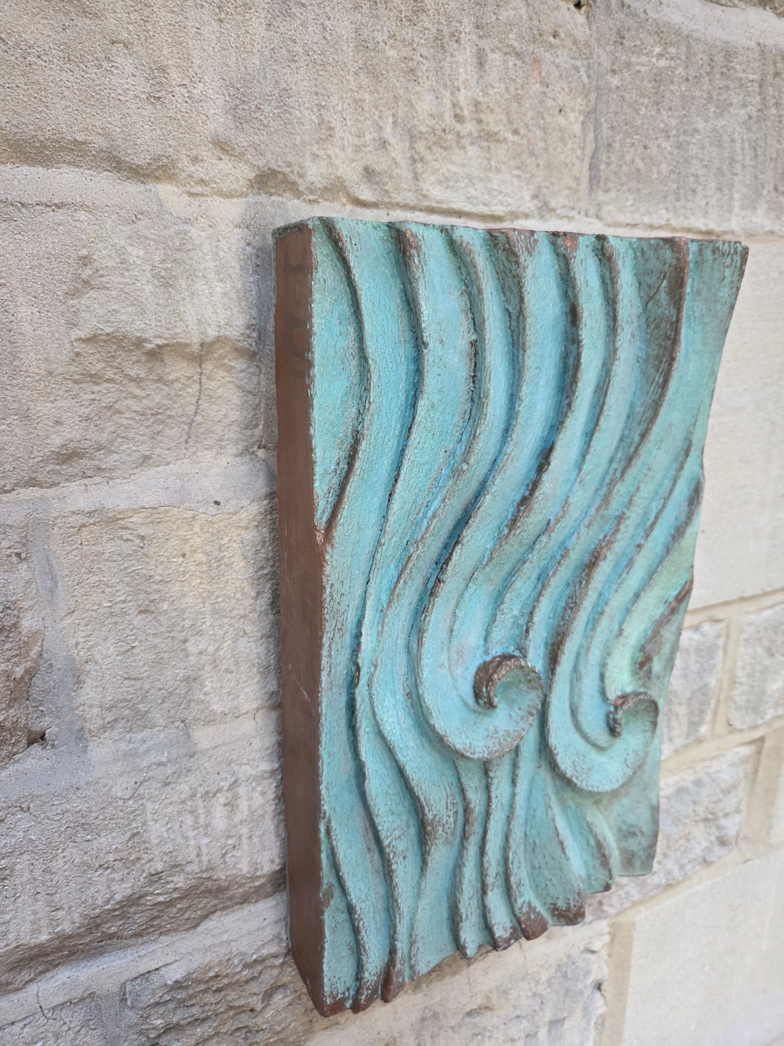 Wave Relief Wall Sculpture in verdigris seen at an angle, showing the depth of the carved waves