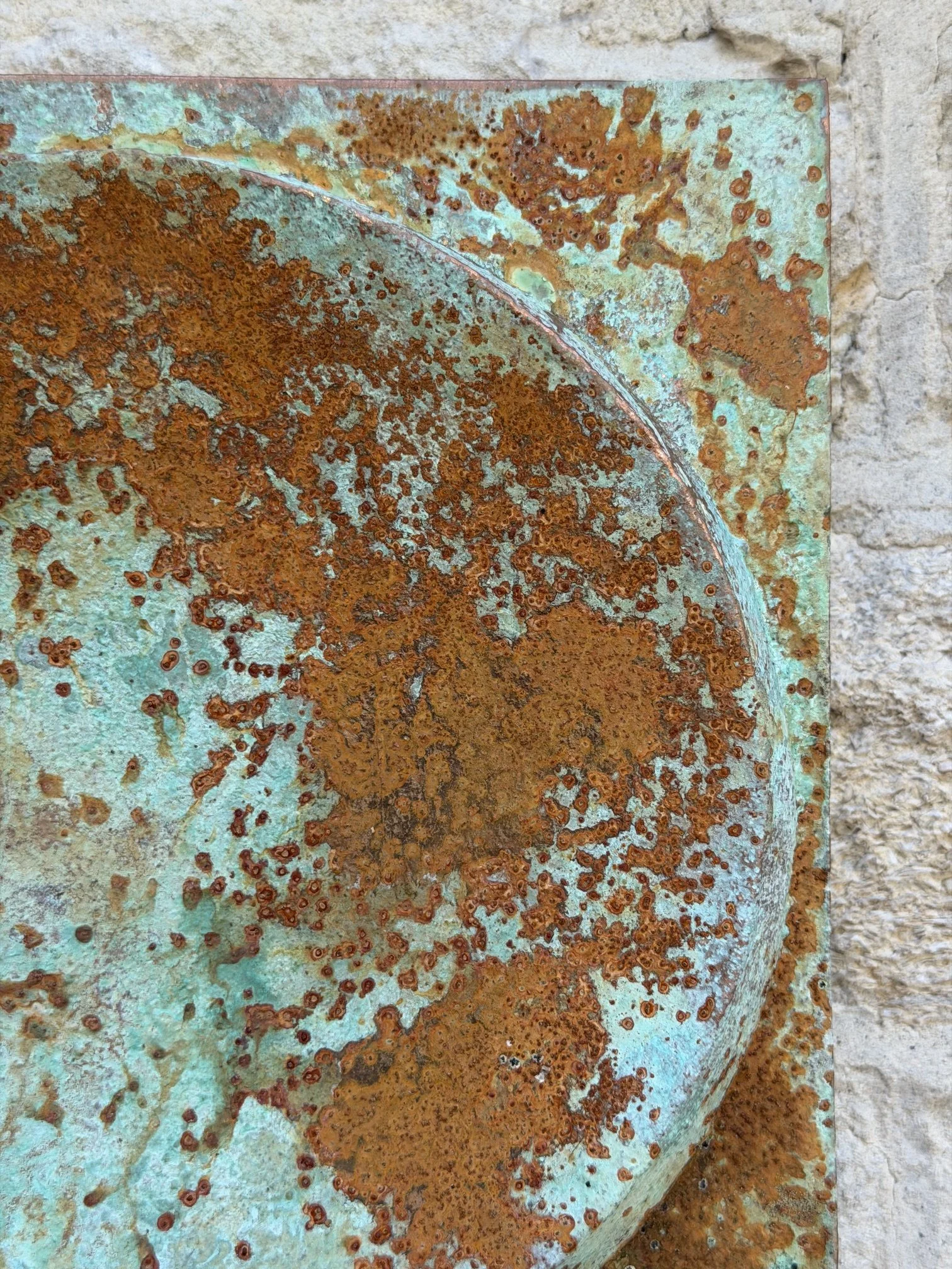 Close view of the Moon Crater Phase Copper Verdigris Wall Sculpture showing rust spreading over green patina