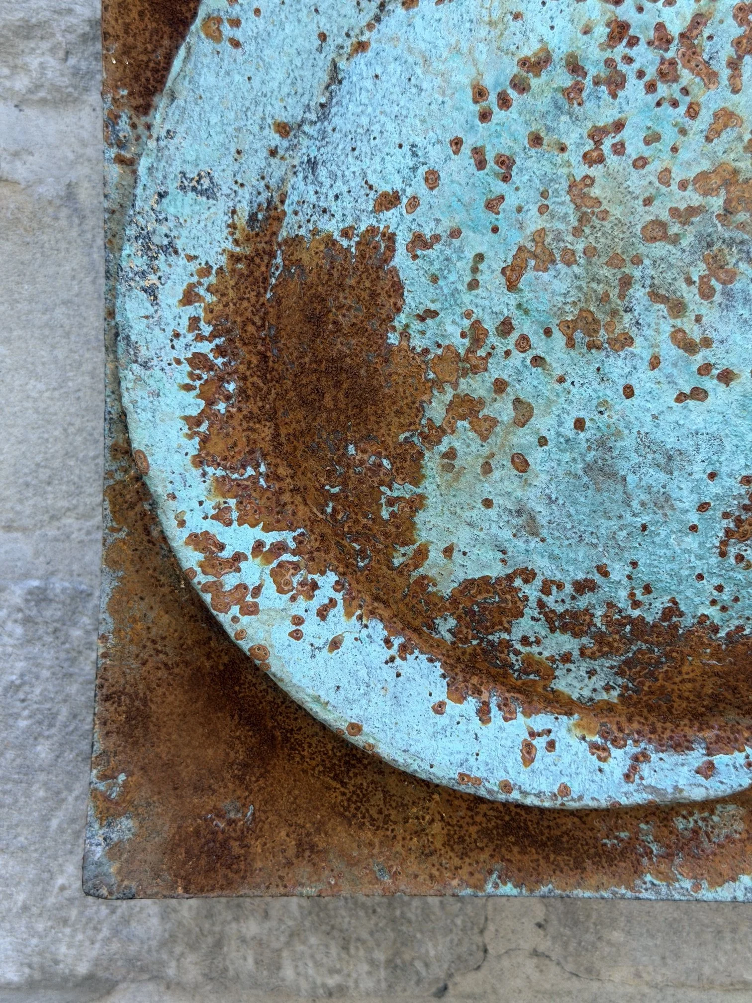 Detail of the Moon Crater Phase Blue Wall Sculpture showing the speckled rust over turquoise patina