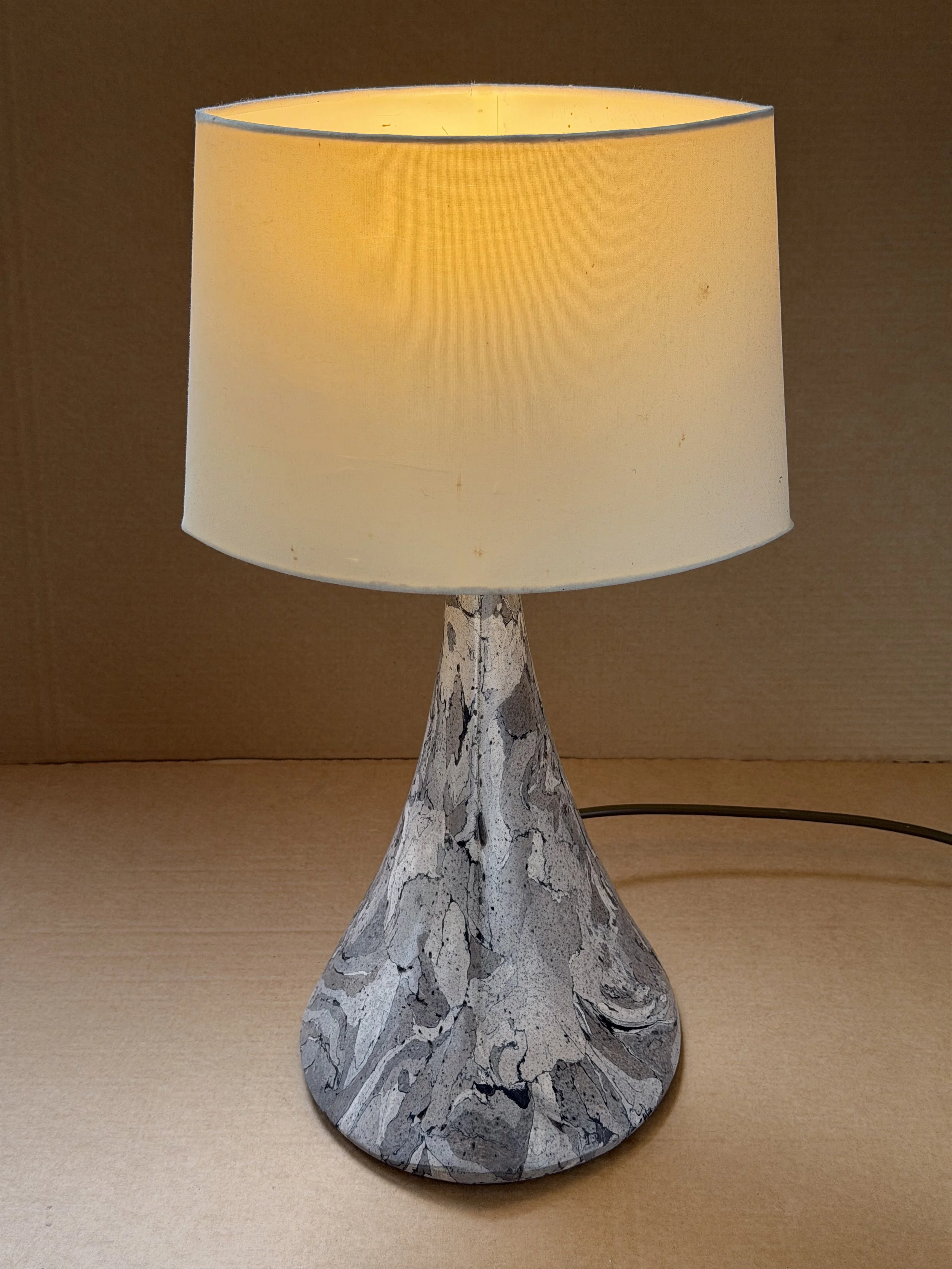 Gray Marble Table Lamp lit, the cream shade glowing above the grey marbled base